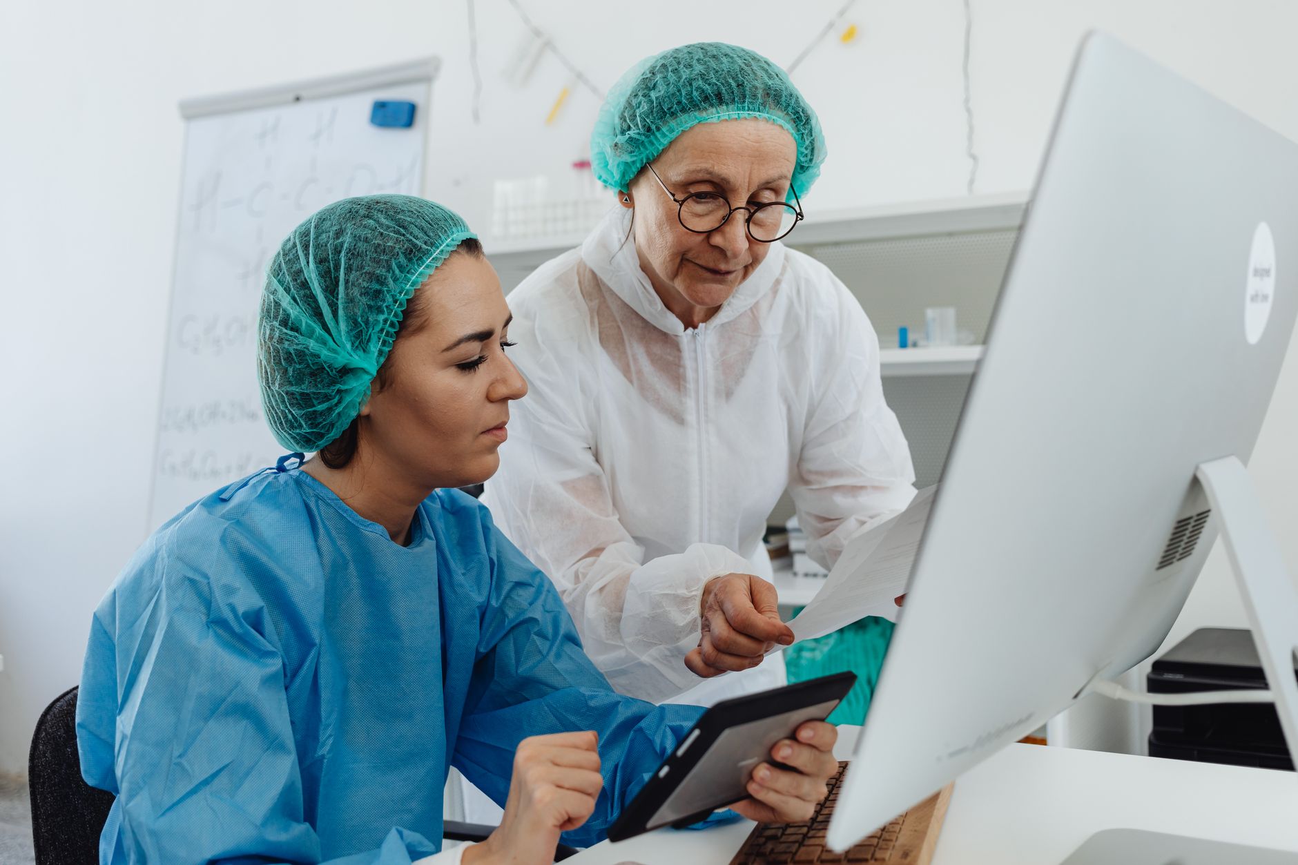 Two healthcare professionals collaborate on clinical trial protocols at a lab.