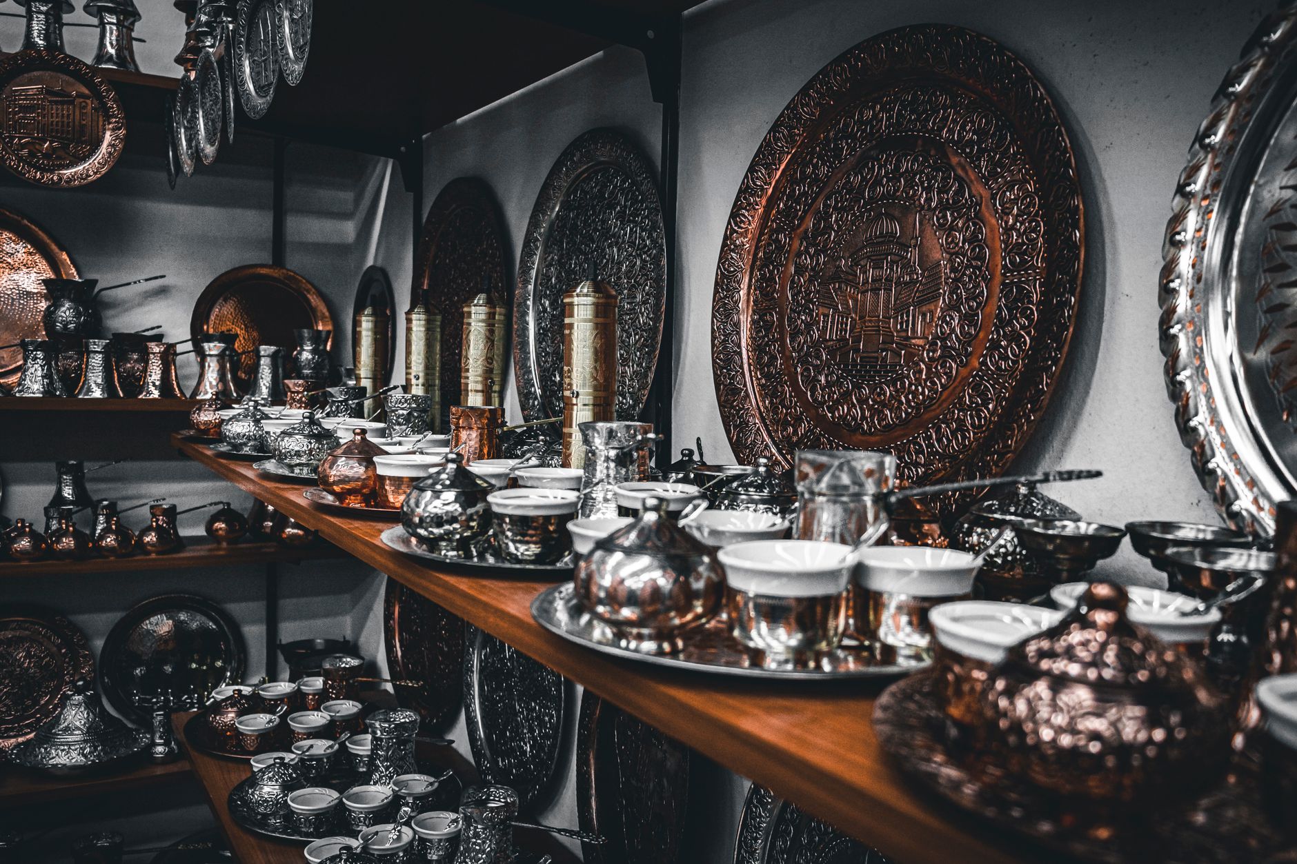 Beautifully arranged Turkish tea sets and decorative plates at a bazaar.