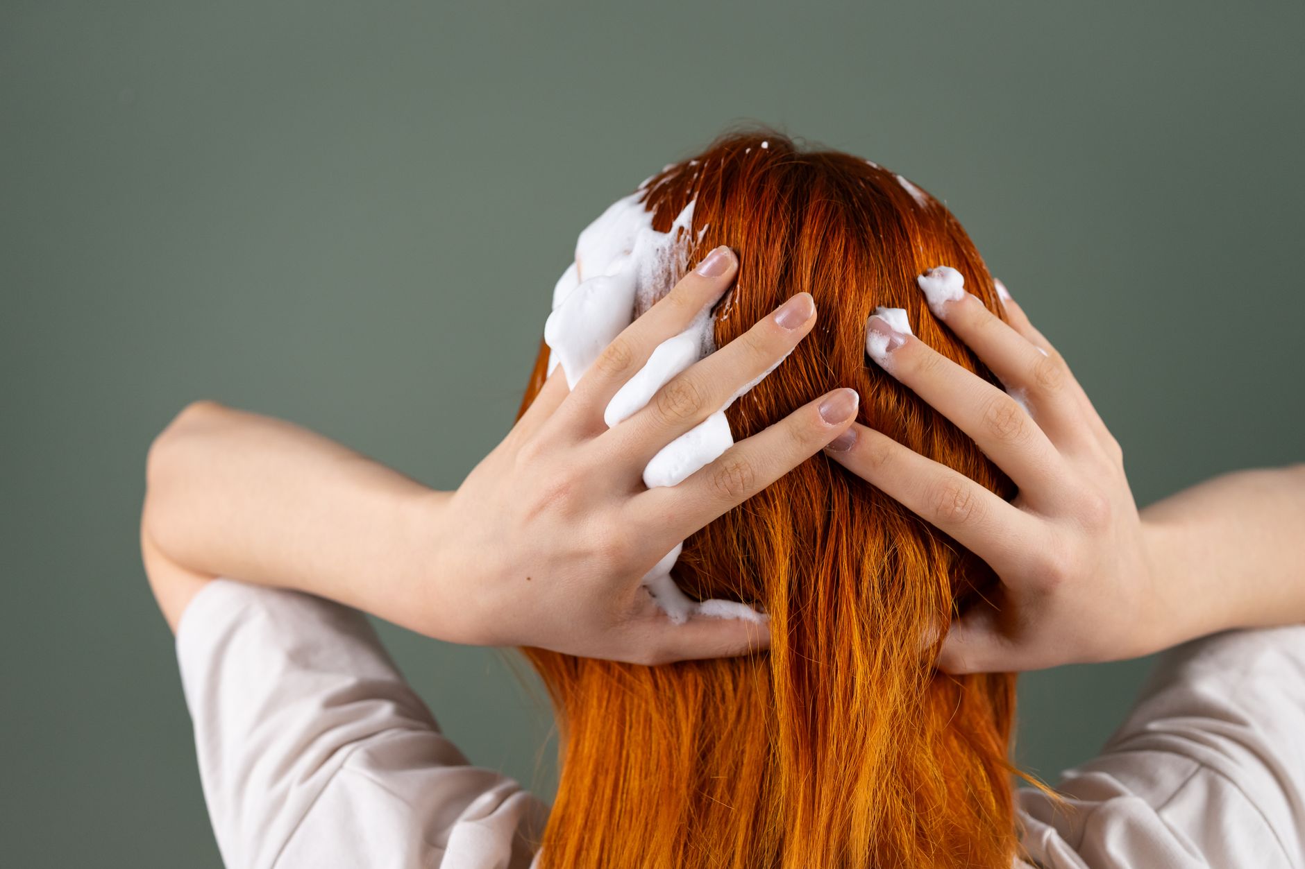 A person applying foam to their hair during a soothing massage in a hammam.