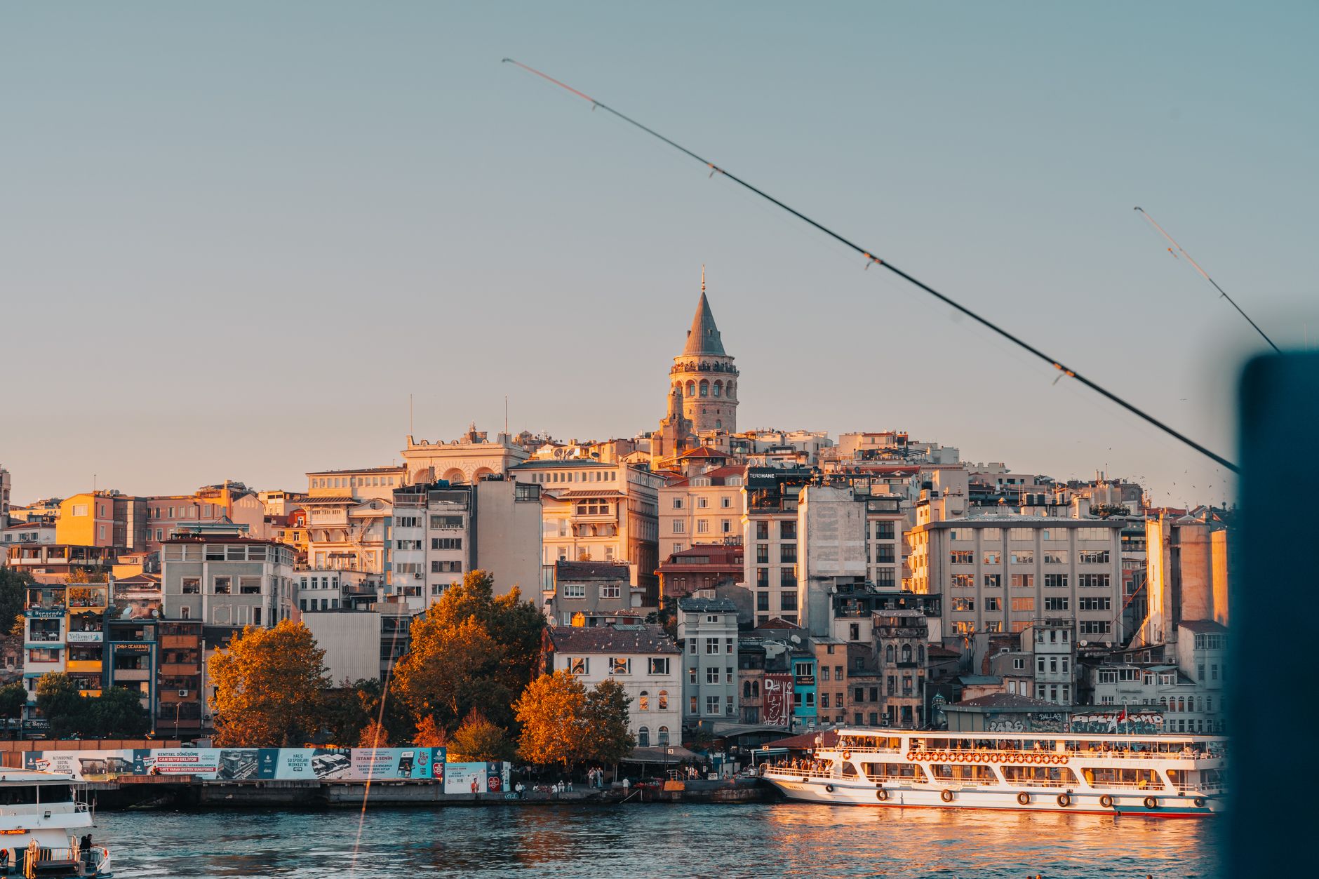 Sunset view of Istanbul with Galata Tower, showcasing waterfront life and vibrant architecture.