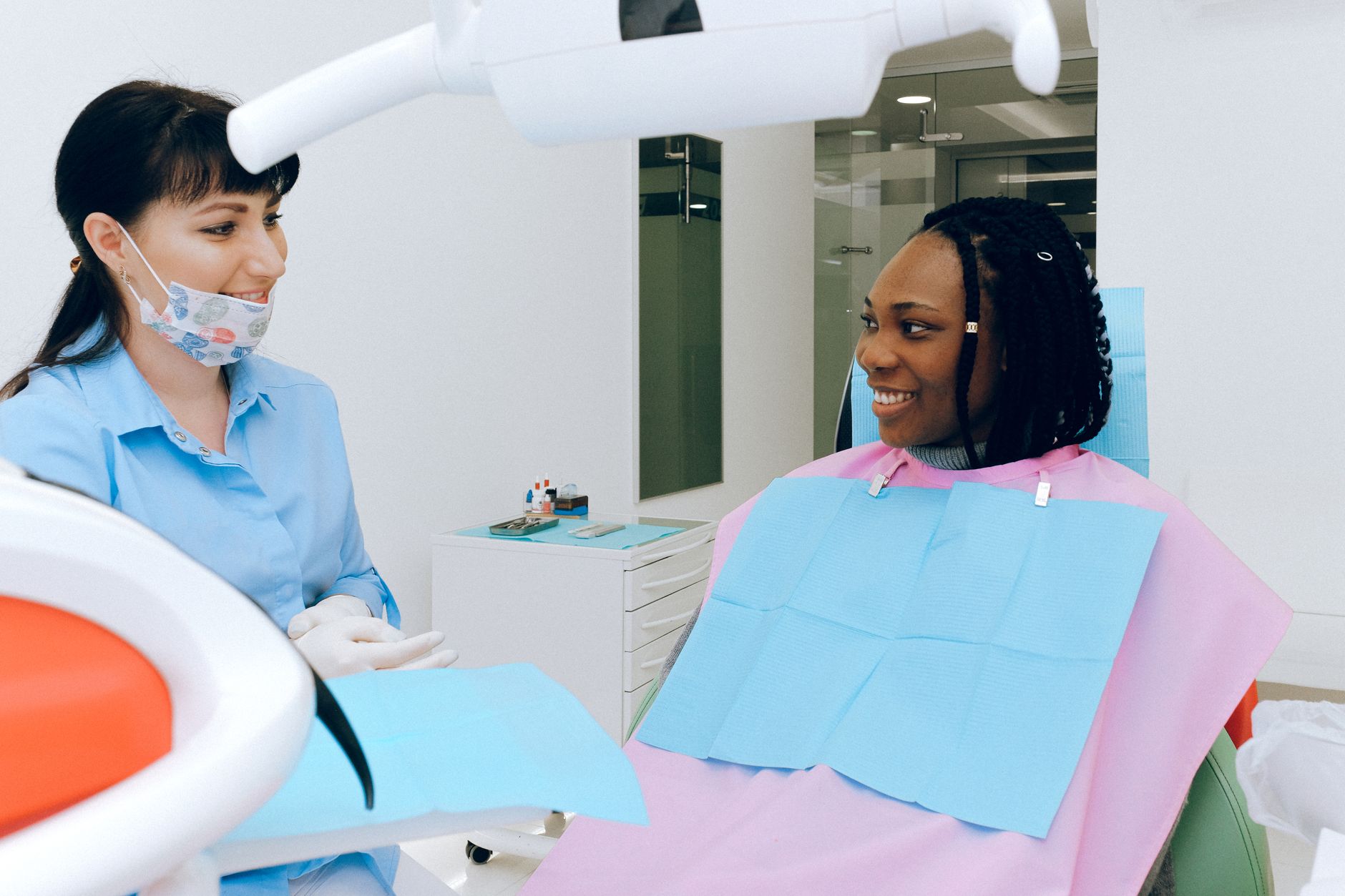 Patient smiling while discussing with a dentist at a modern dental clinic.