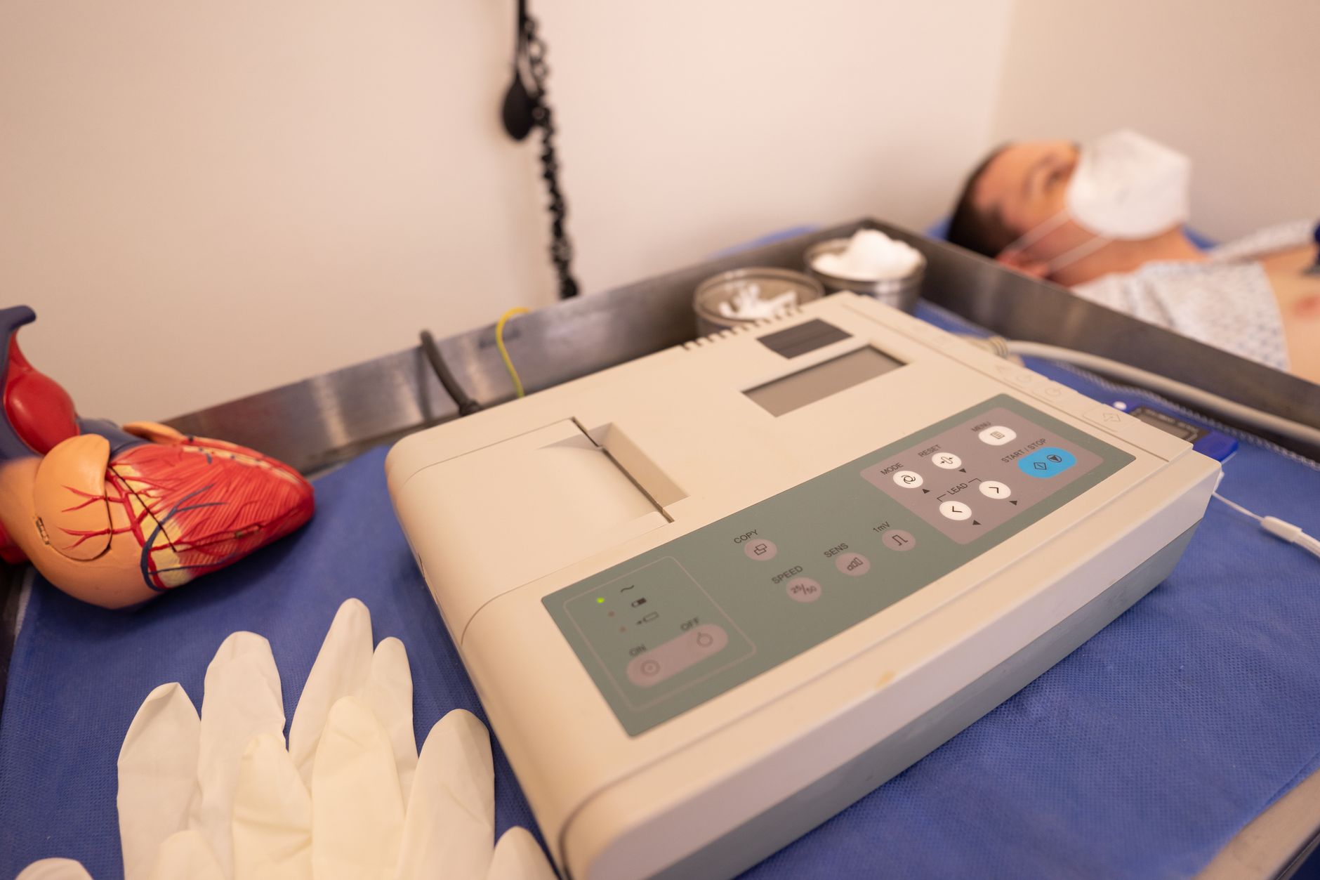 Close-up of cardiology equipment and artificial heart model in a clinical setting.