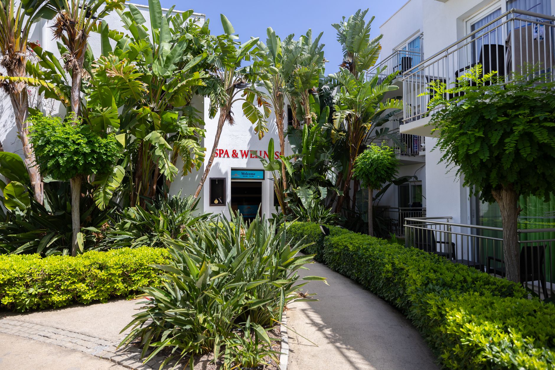 Entrance to a spa and wellness center surrounded by lush greenery in Antalya.