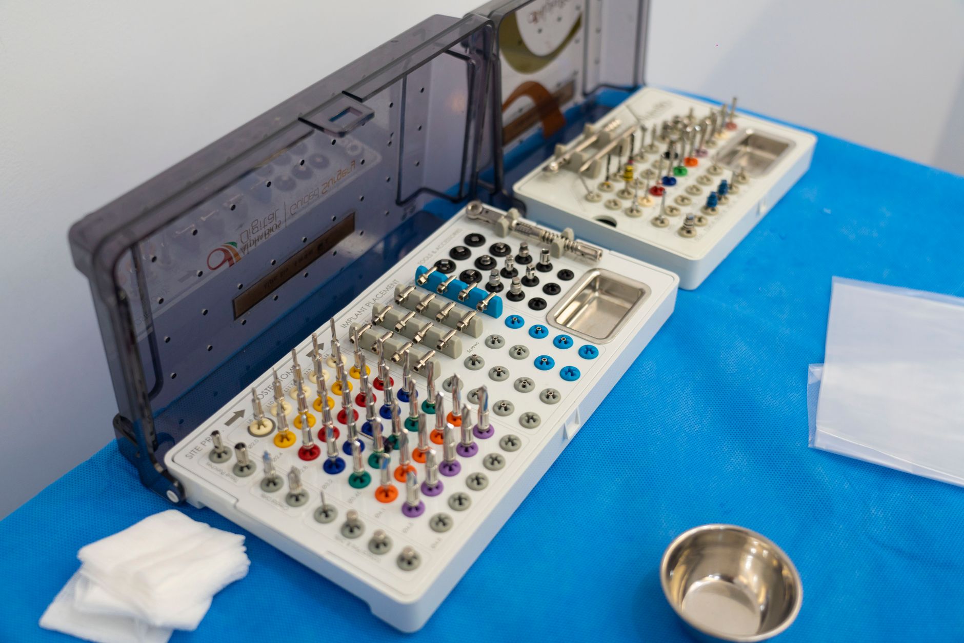 Surgical tools for bone-anchored hearing implants laid out on a blue surface.