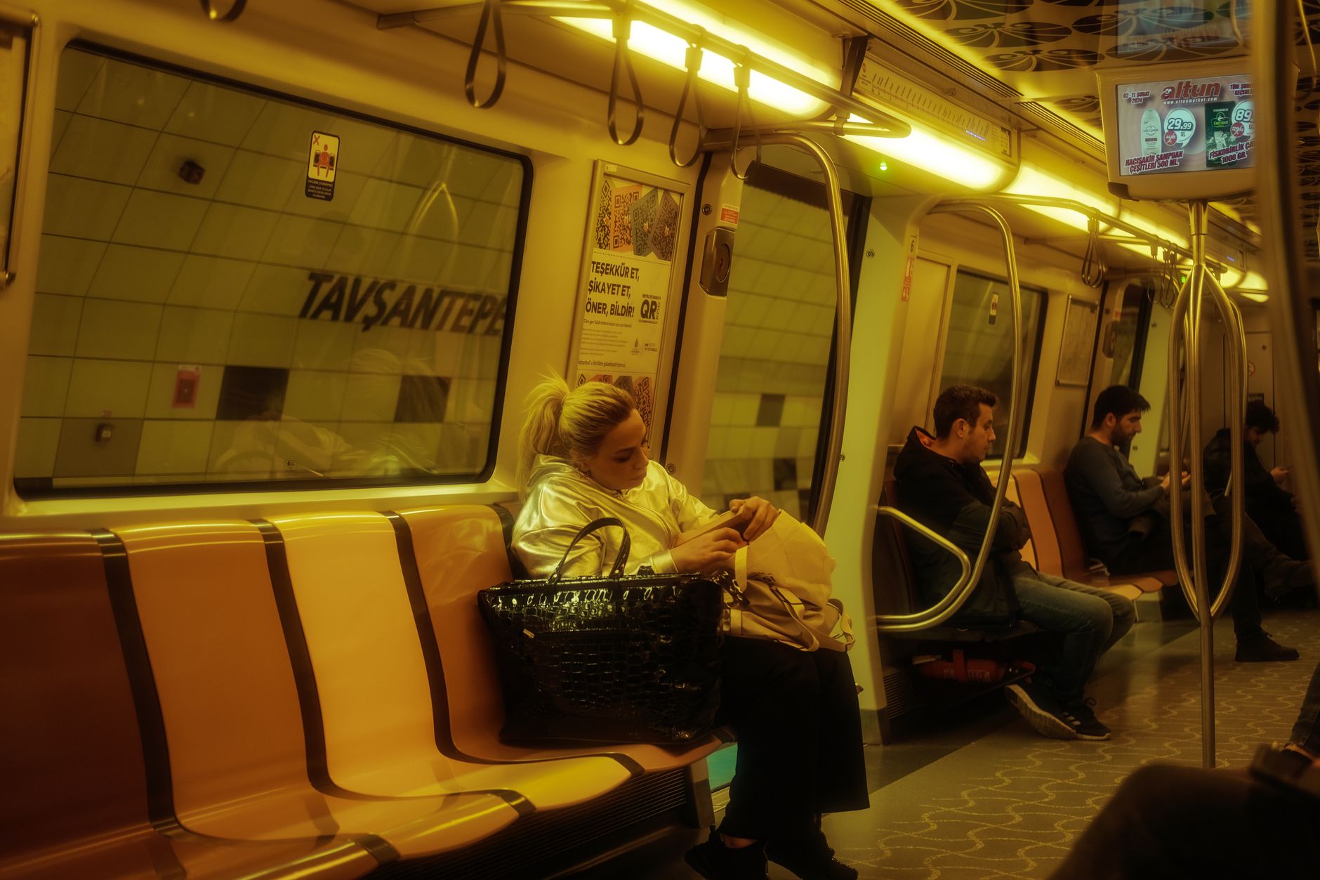 Bir YHT yüksek hızlı tren vagonunda rahatlayan ve telefonlarını kullanan yolcular.