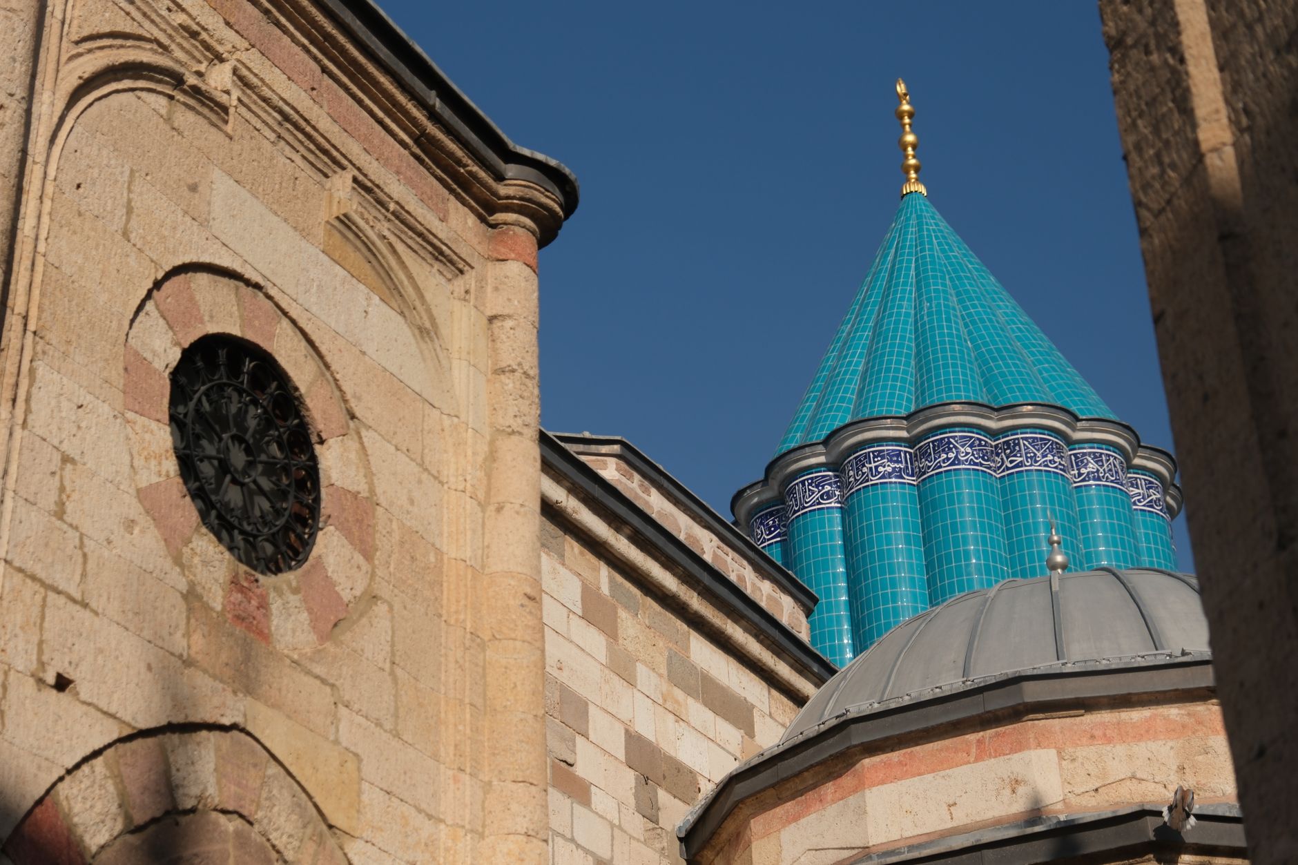 Konya, Türkiye'de mavi çinili bir kubbe ve taş duvarların yakın çekimi.