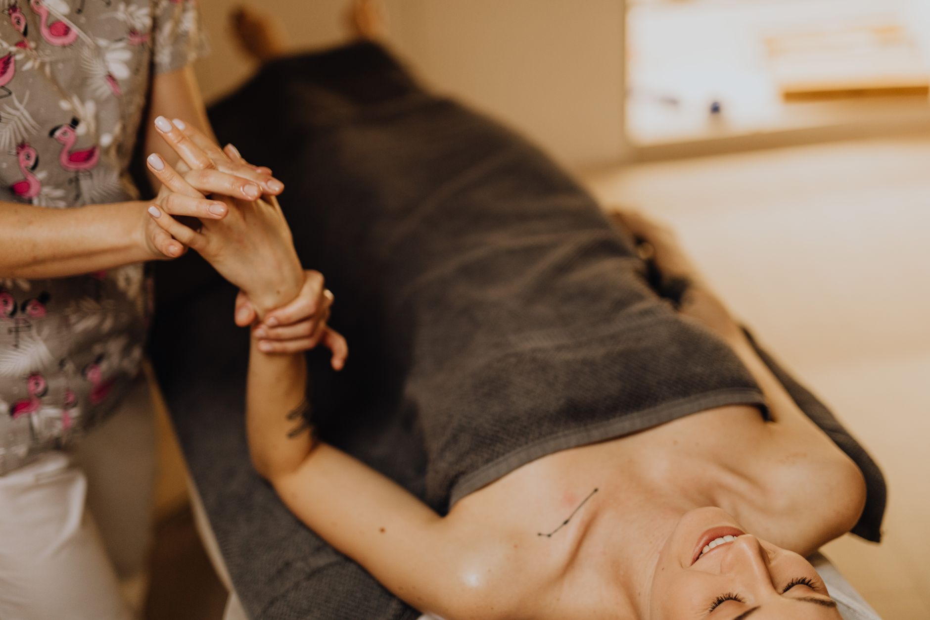 A therapist performing lymphatic drainage on a patient's arm, showcasing relaxation.