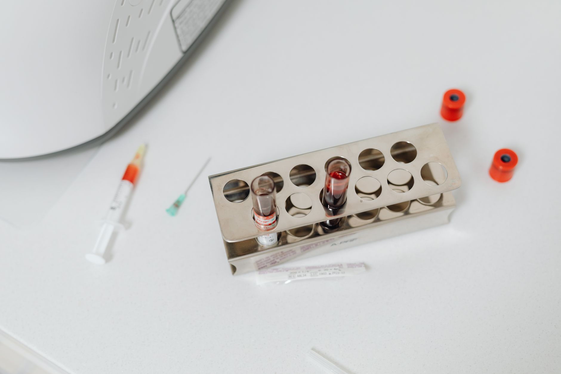 Blood vials and syringes on a laboratory countertop for testing.