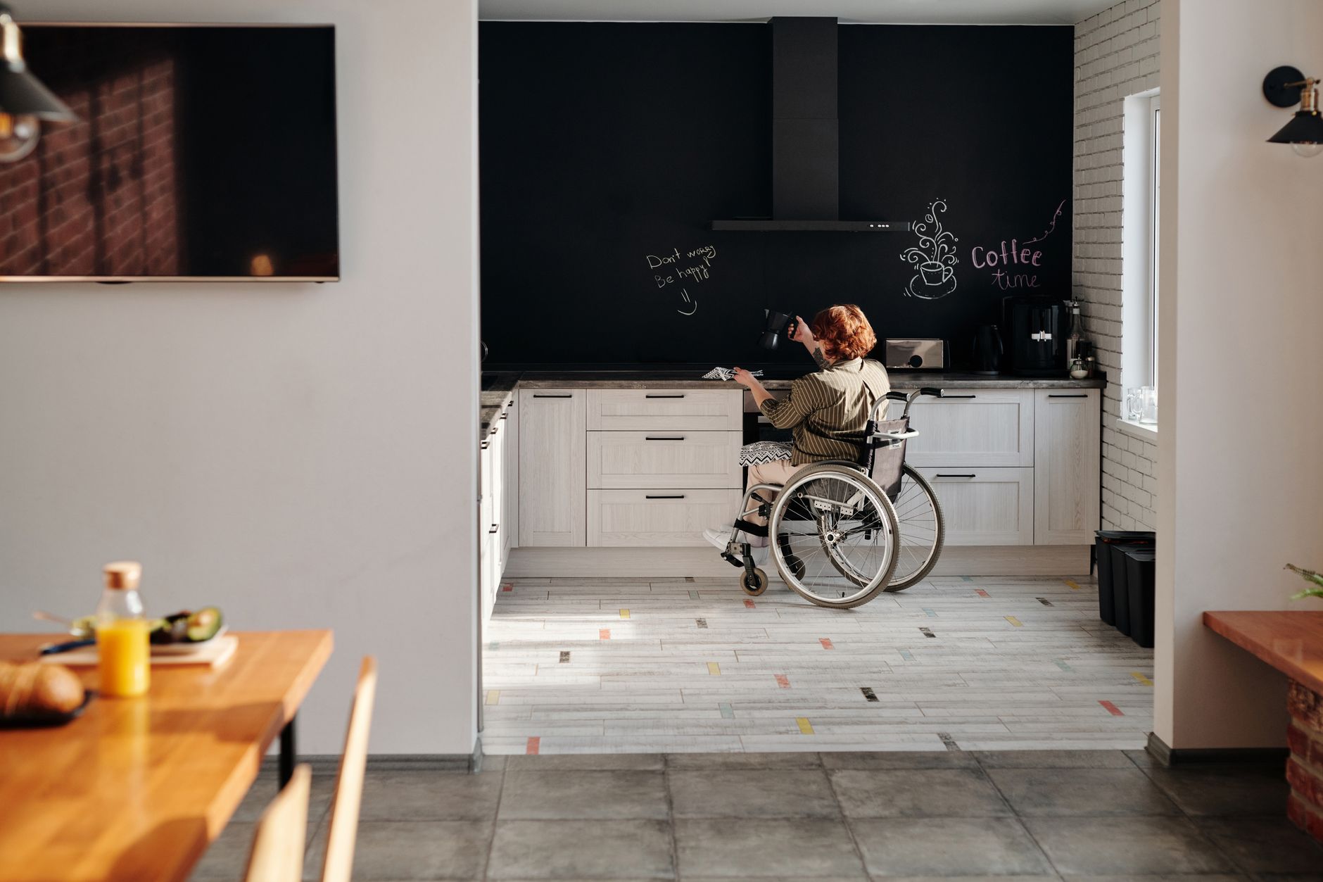 A patient in a wheelchair practices cooking in a stylish kitchen.