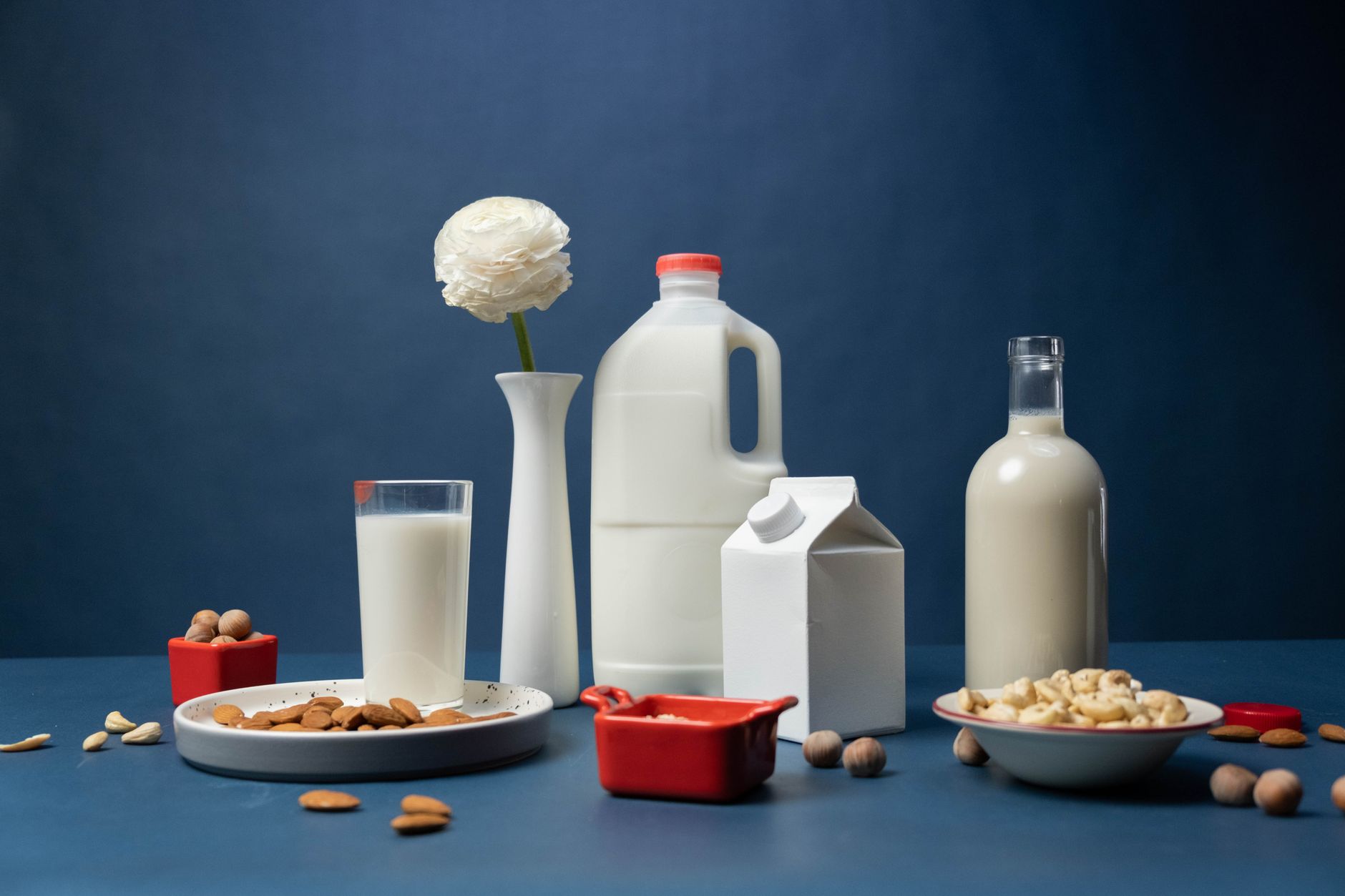 A collection of plant-based milks in carton packaging on a kitchen shelf.