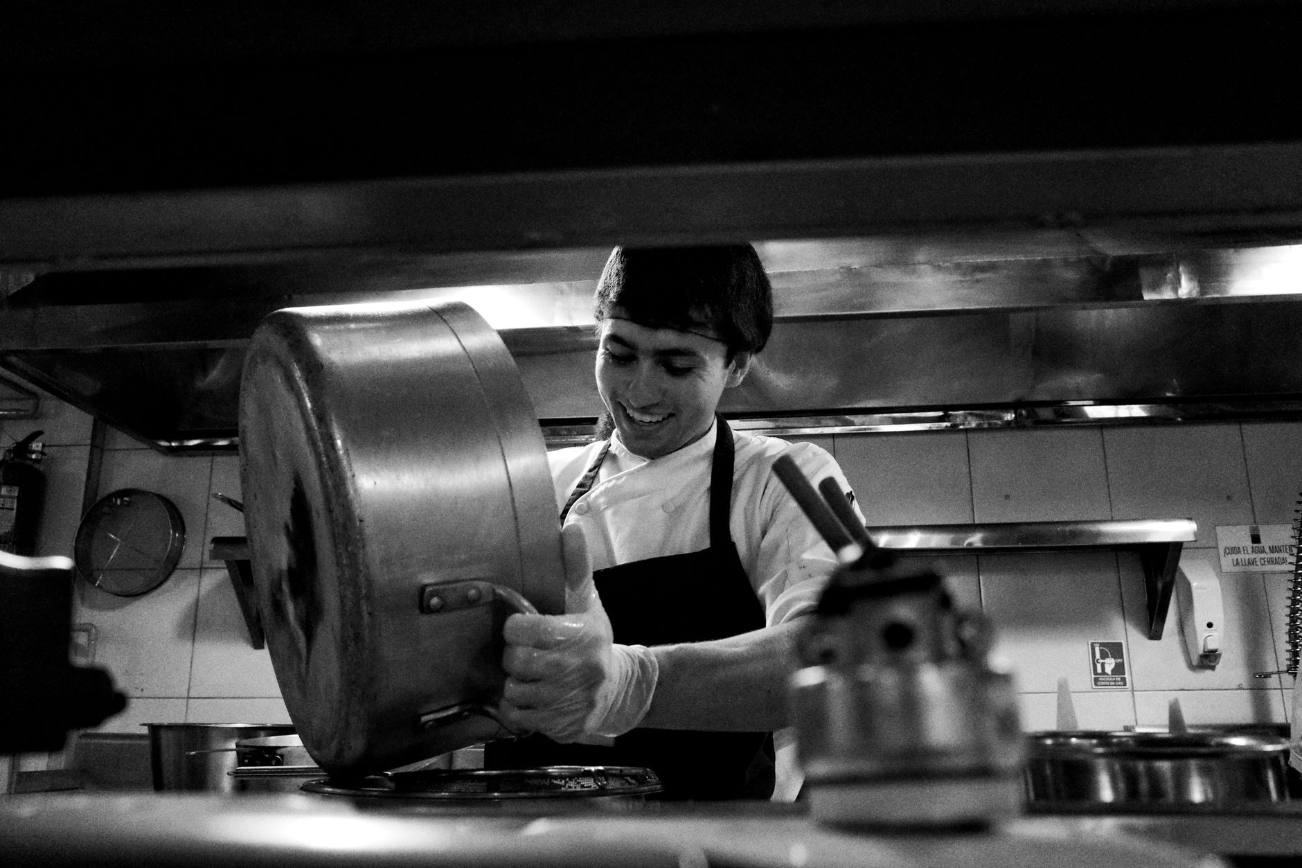 Chef in a hospital kitchen meticulously preparing a special allergen-free meal while wearing gloves.