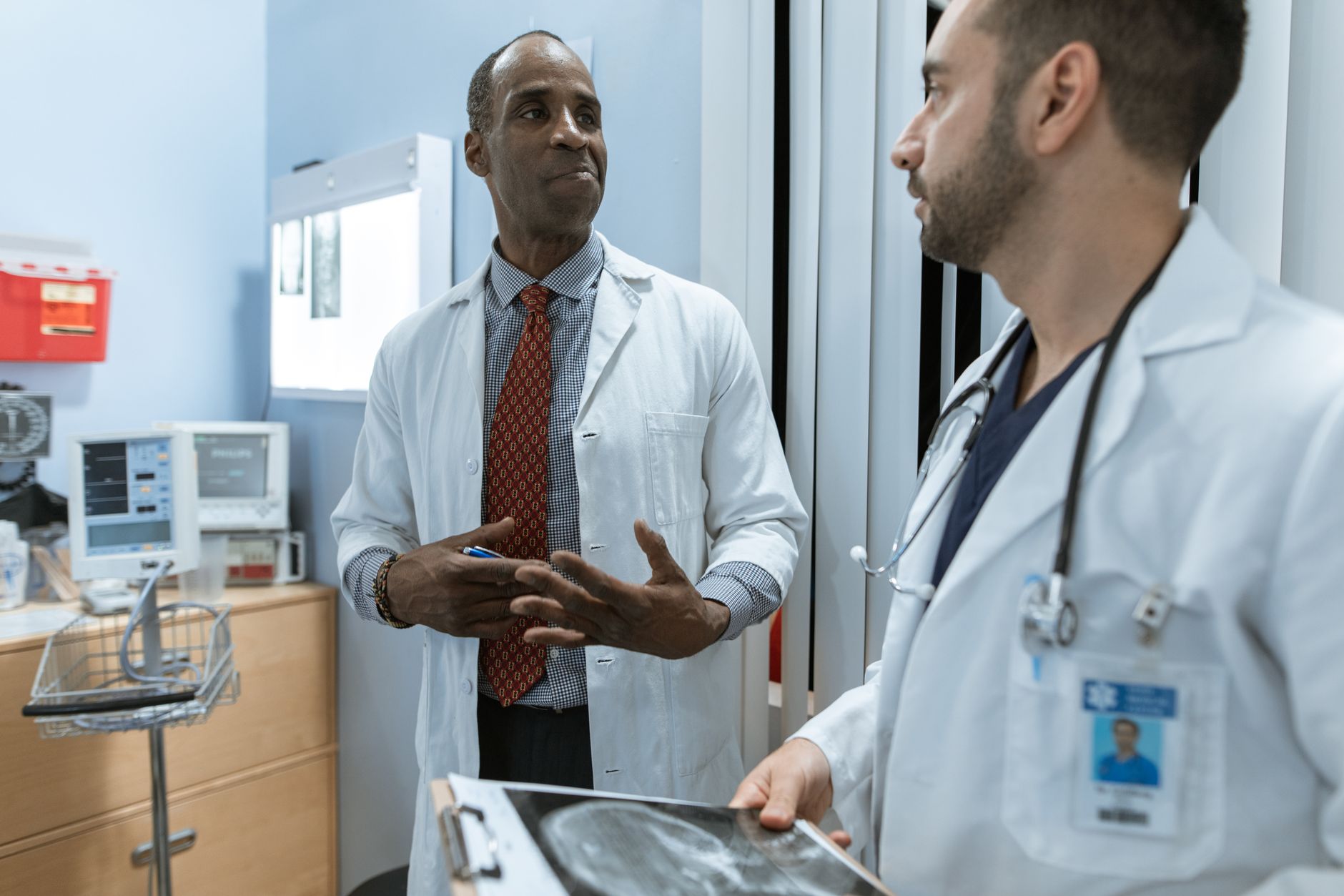 A gynecologist and urologist discussing an X-ray in a hospital consultation room.