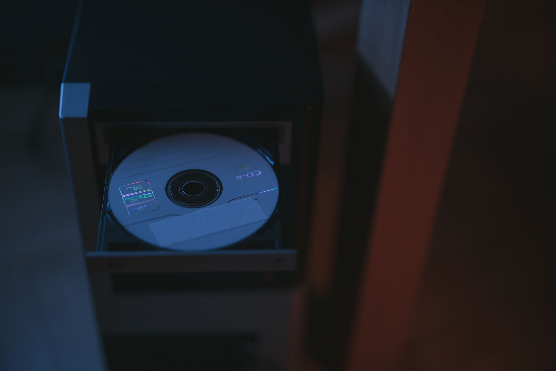 A CD labeled CD-R inserted in a dark drawer, possibly containing medical imaging files.