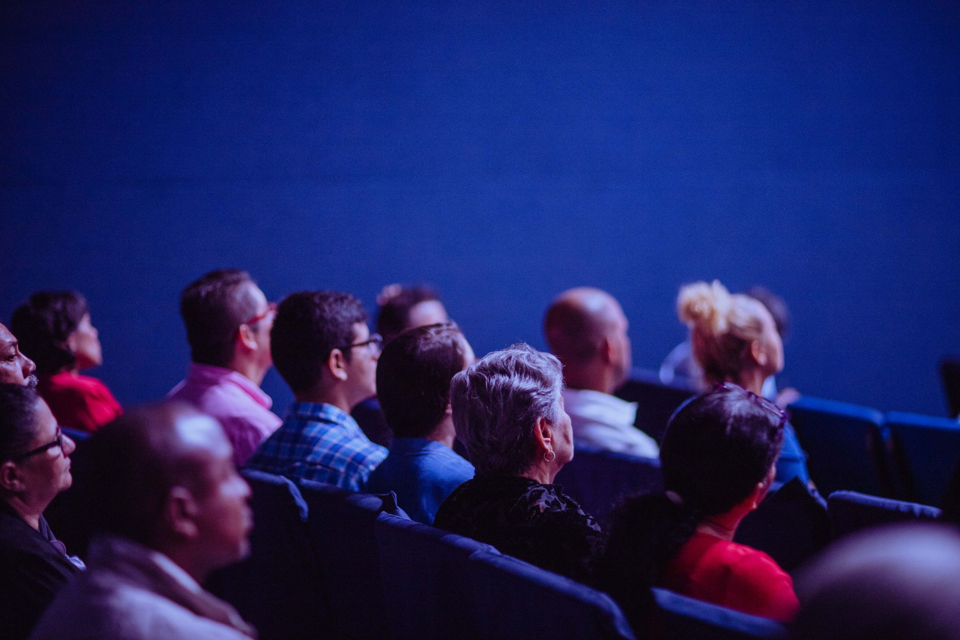 Audience of dental professionals engaged during a lecture in a conference hall.