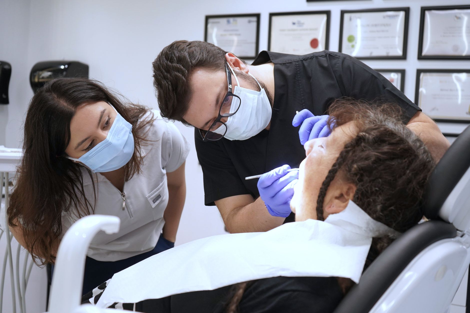Dental professionals demonstrate new techniques at a workshop, attending to a patient.