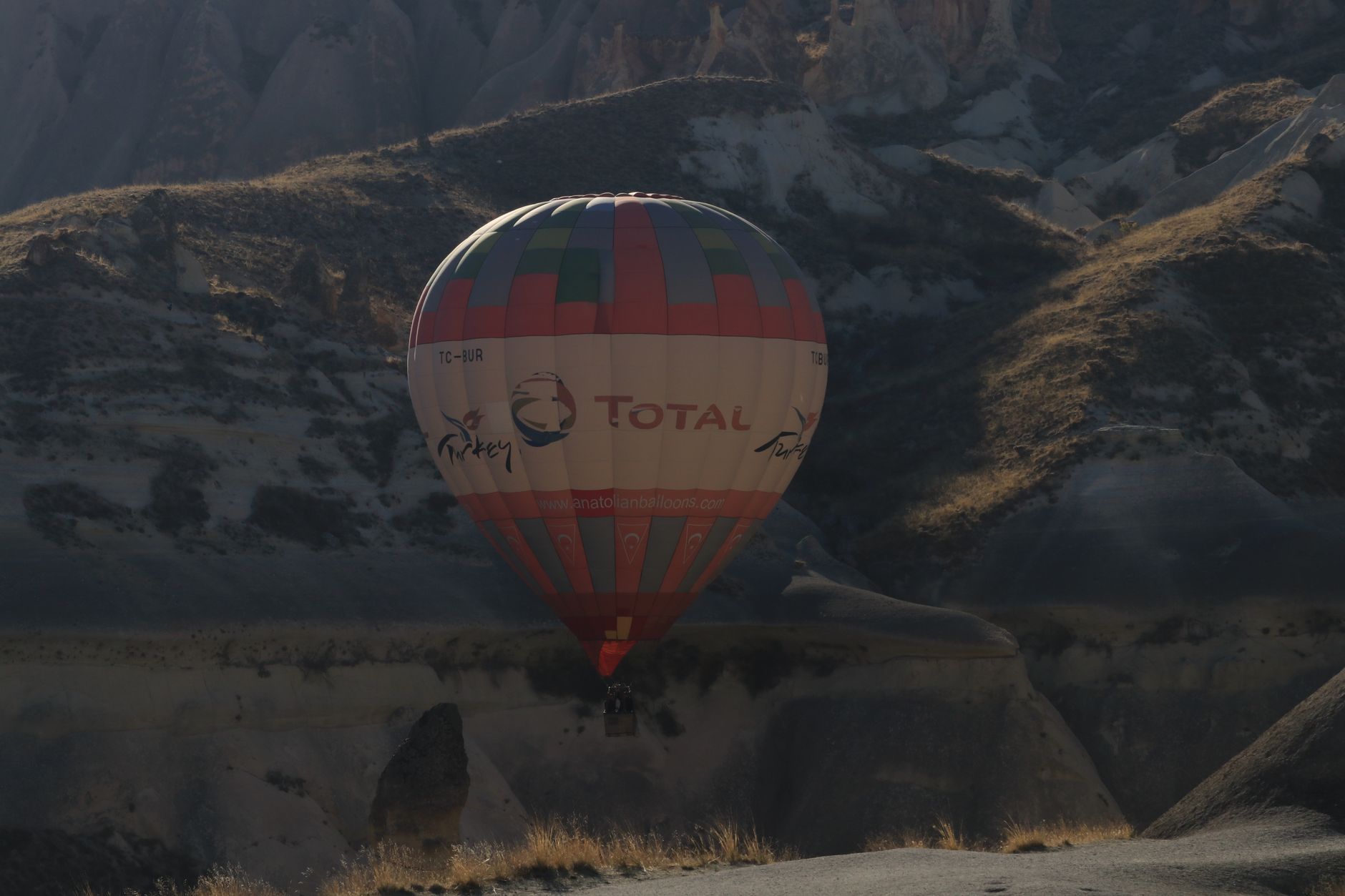A colorful hot air balloon ascends over the Taurus Mountains near Antalya.