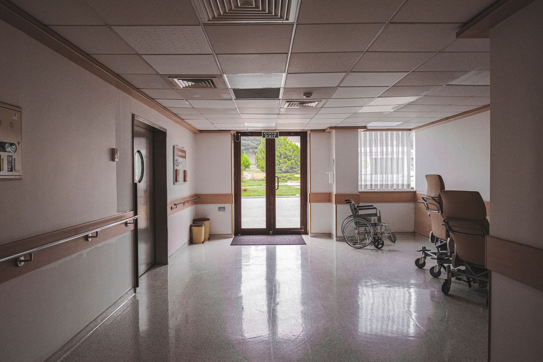 Interior of a modern Turkish hospital featuring an exit door, wheelchair, and clean environment.