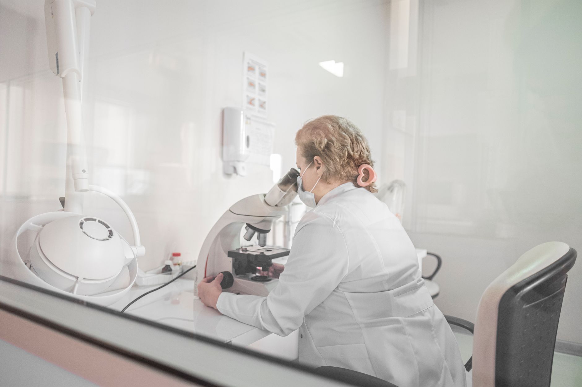 Embryologist analyzing samples under a microscope in a modern IVF lab.
