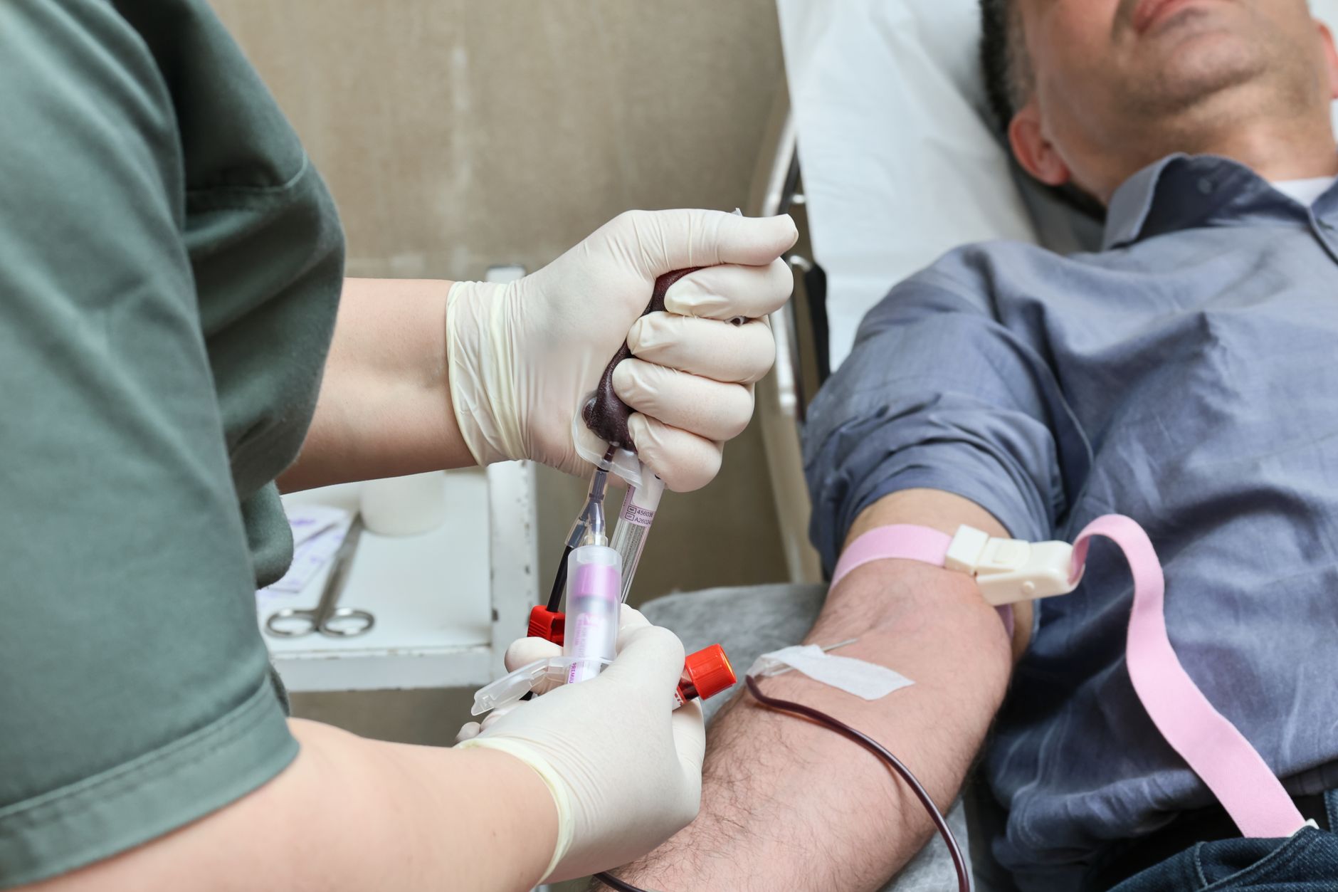 A healthcare worker draws blood from a patient for organ donor compatibility testing.