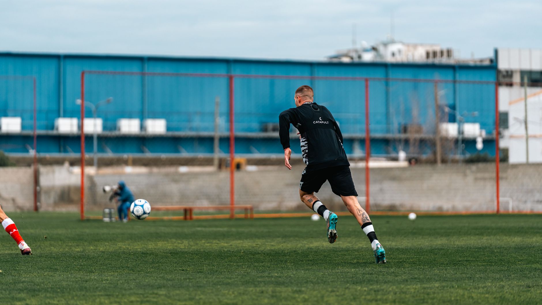 A footballer training on a pitch in Türkiye, showing determination after recovering from a knee injury.