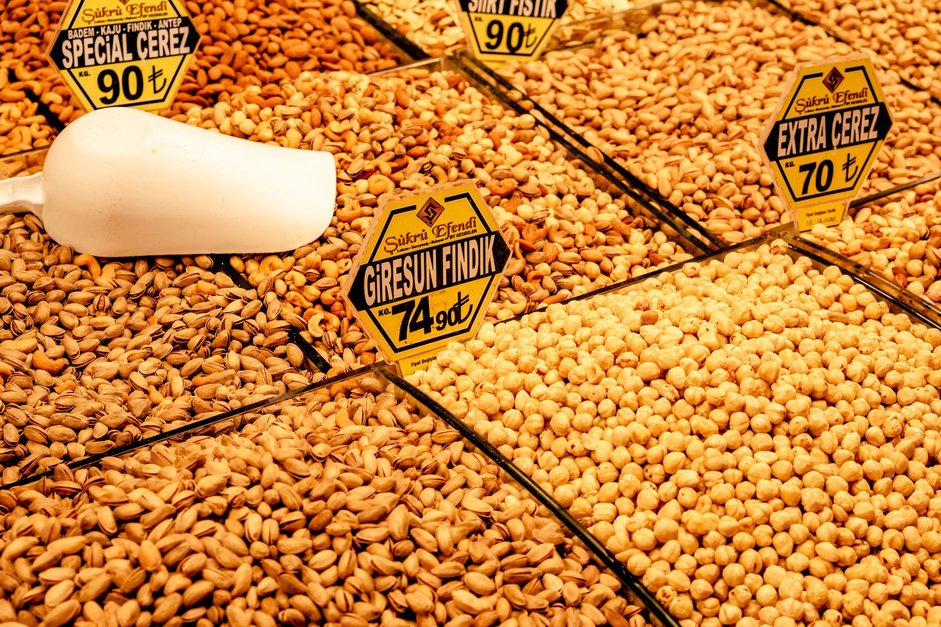 A variety of nuts displayed at a market in Giresun, Turkey, with price signs.
