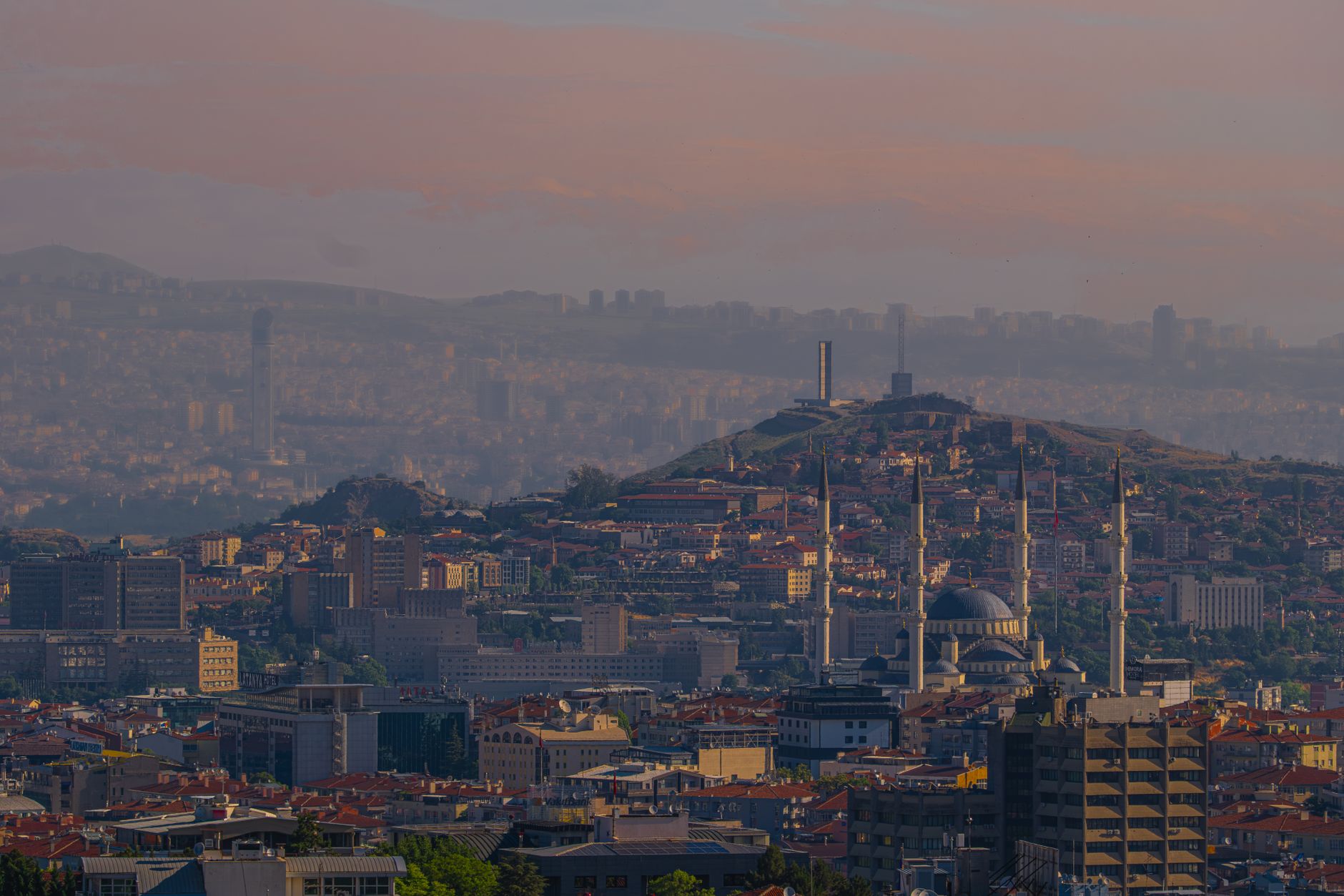 Panoramic view of Ankara's cityscape featuring modern buildings and a mosque.