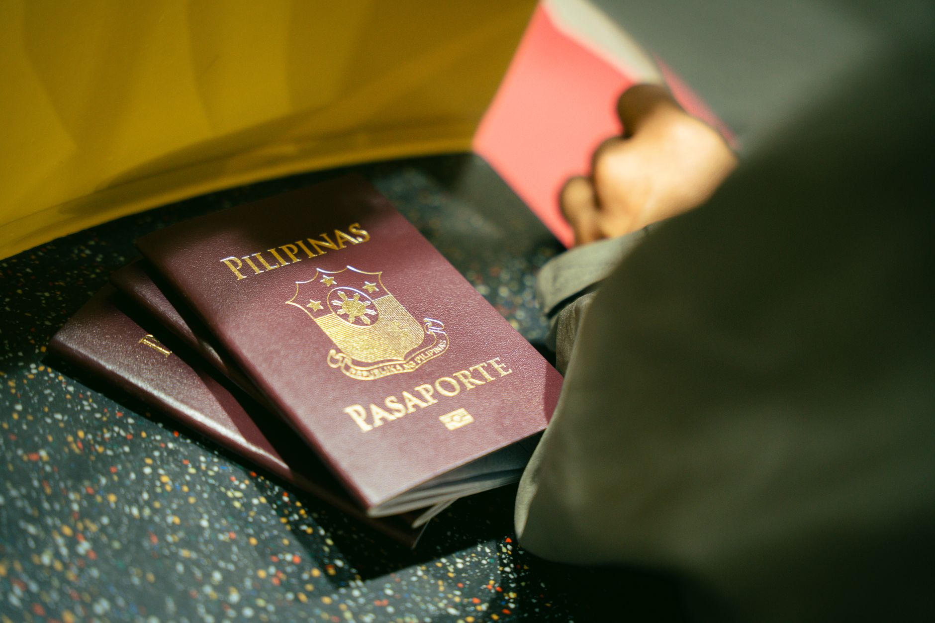 Close-up of Filipino passports titled 'Pilipinas Pasaporte' on a counter.