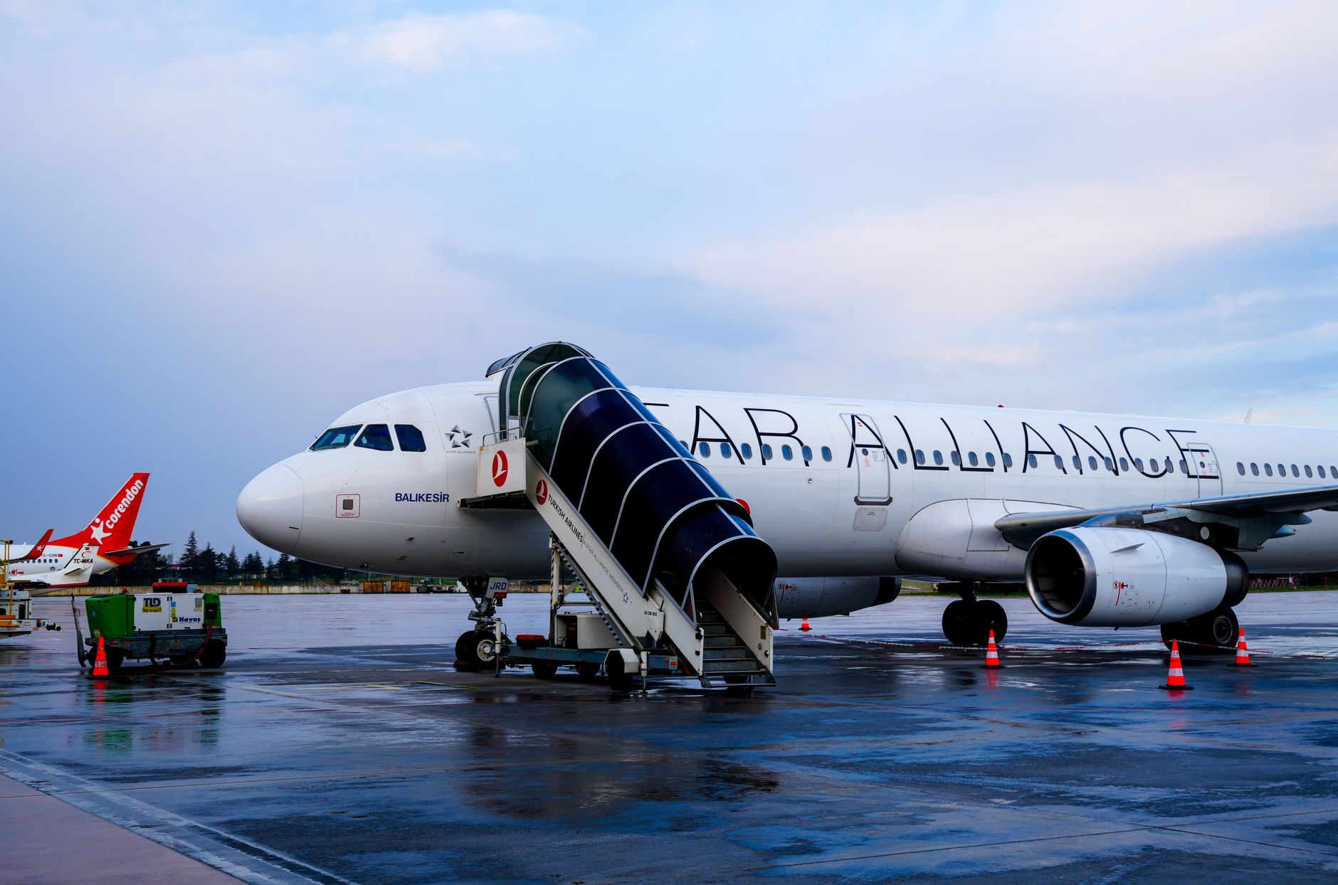Air Alliance airplane at Istanbul Airport with boarding stairs and luggage at the gate.