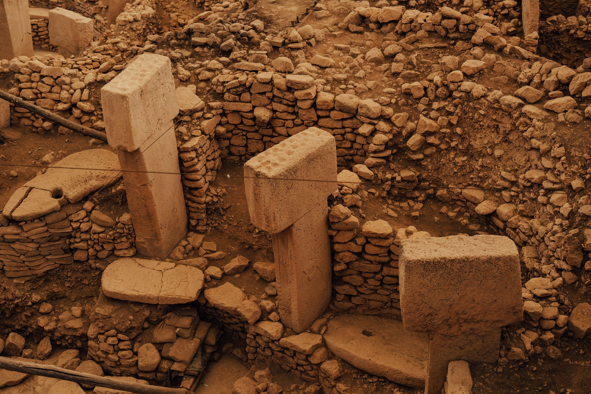 نمای هوایی از گوبکلی‌تپه، ستون‌ها و دیوارهای سنگی باستانی، نمایش‌دهنده تمدن اولیه بشری.