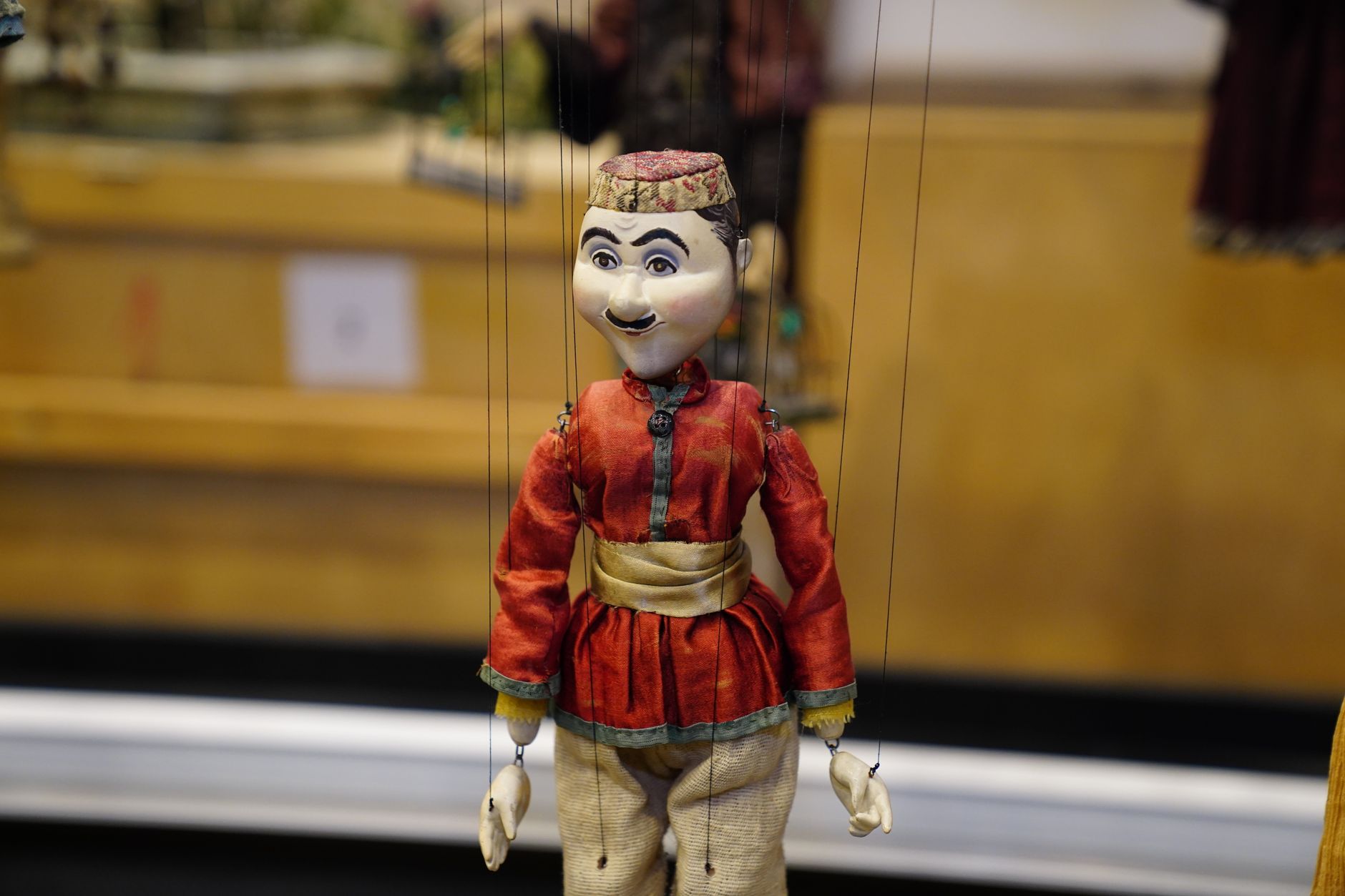 A vintage marionette dressed in a red outfit, showcasing craftsmanship in a Turkish toy museum.
