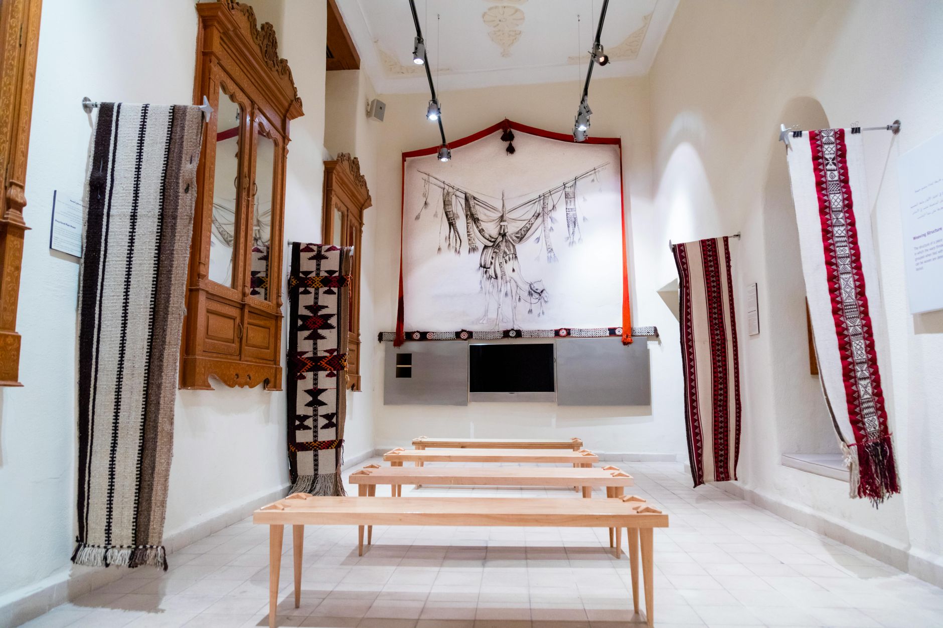 Interior view of Anatolian ethnographic museum showcasing traditional textiles and wooden furniture.