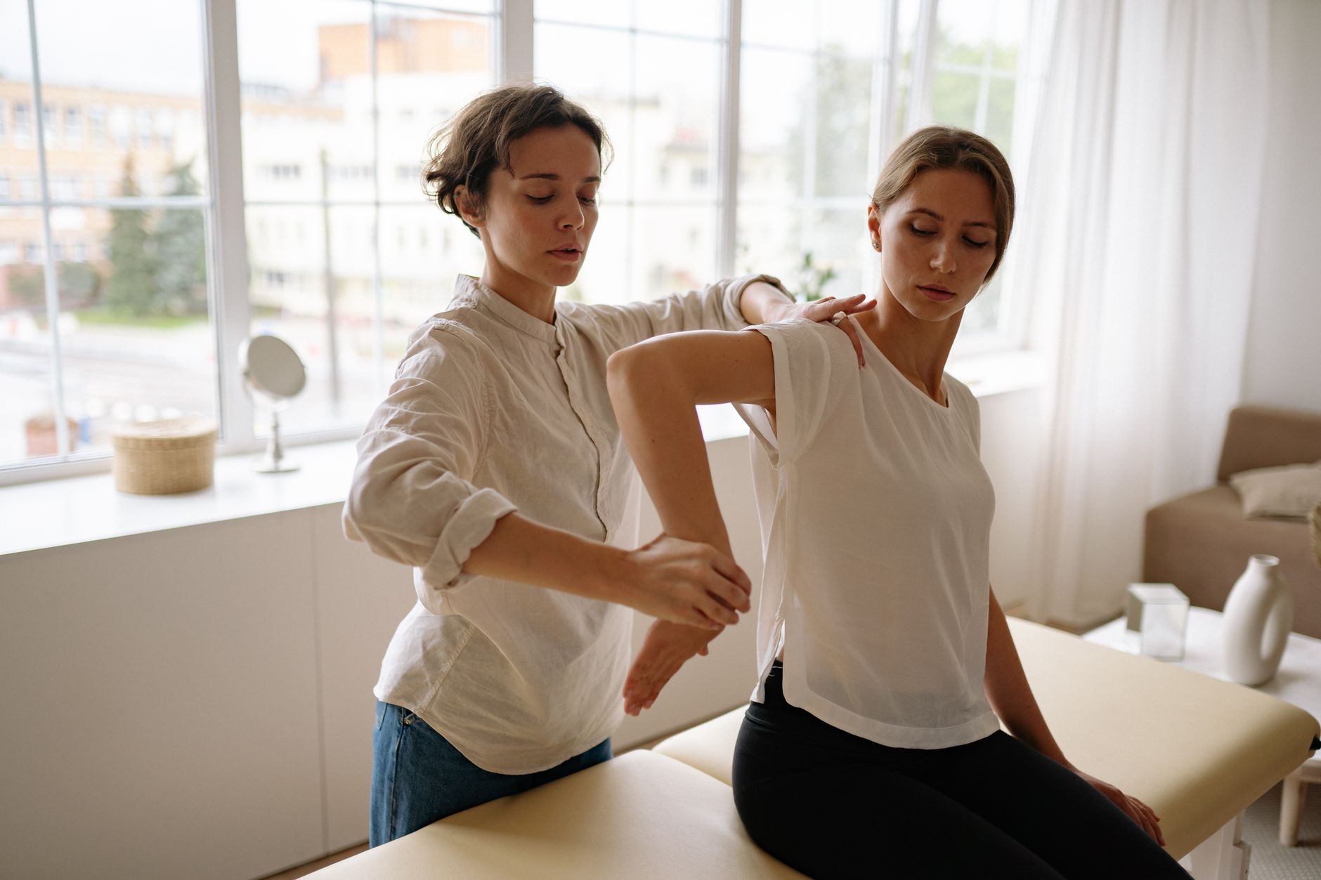 An occupational therapist assists a patient with fine motor skills exercises in a bright therapy room.