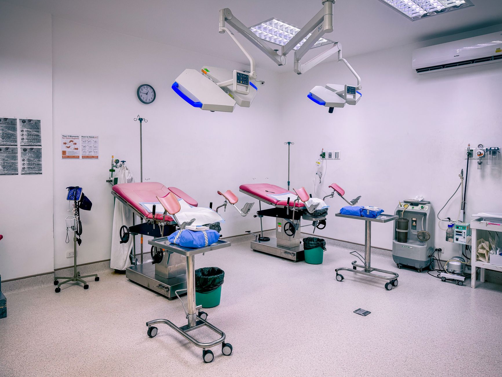 Interior of a surgical theatre featuring pink examination tables and medical equipment.