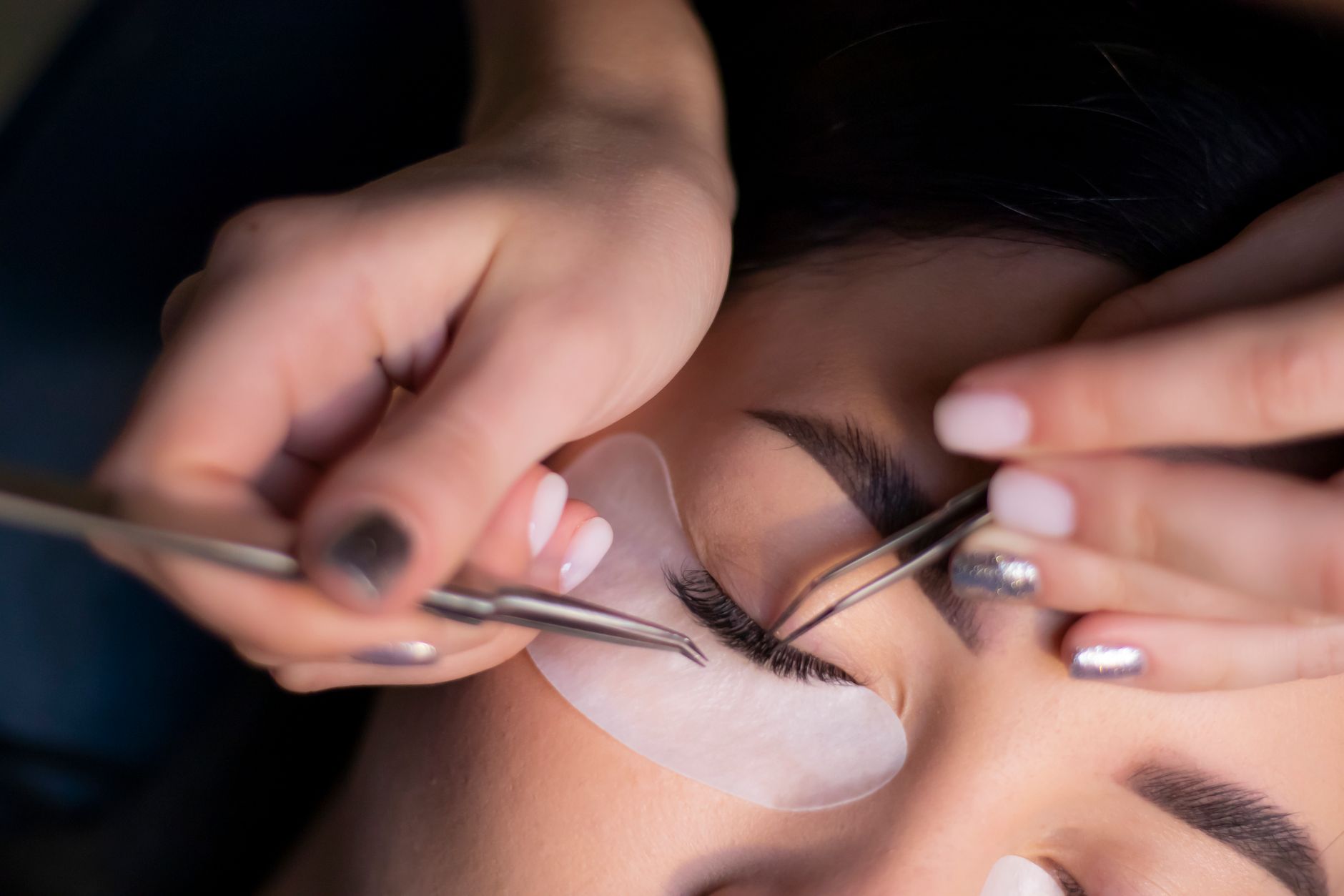 Surgeon using precision instruments during eyelid surgery on a patient.
