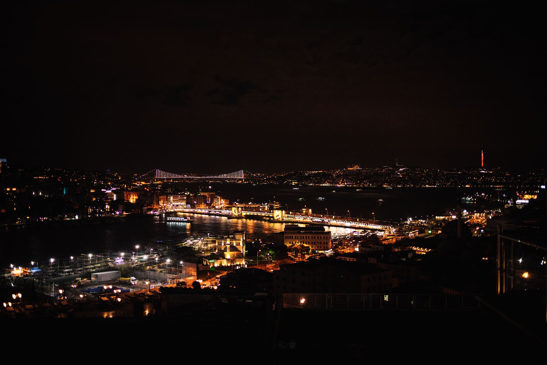 A breathtaking night view of the illuminated Bosphorus in Istanbul with city lights reflecting on the water.
