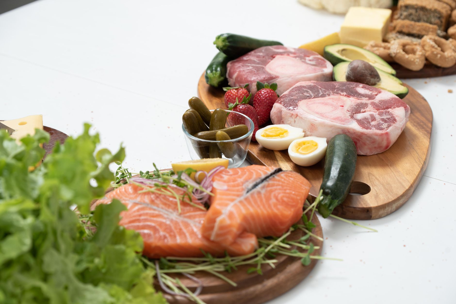 A vibrant ketogenic food platter featuring salmon, avocado, eggs, and various vegetables.
