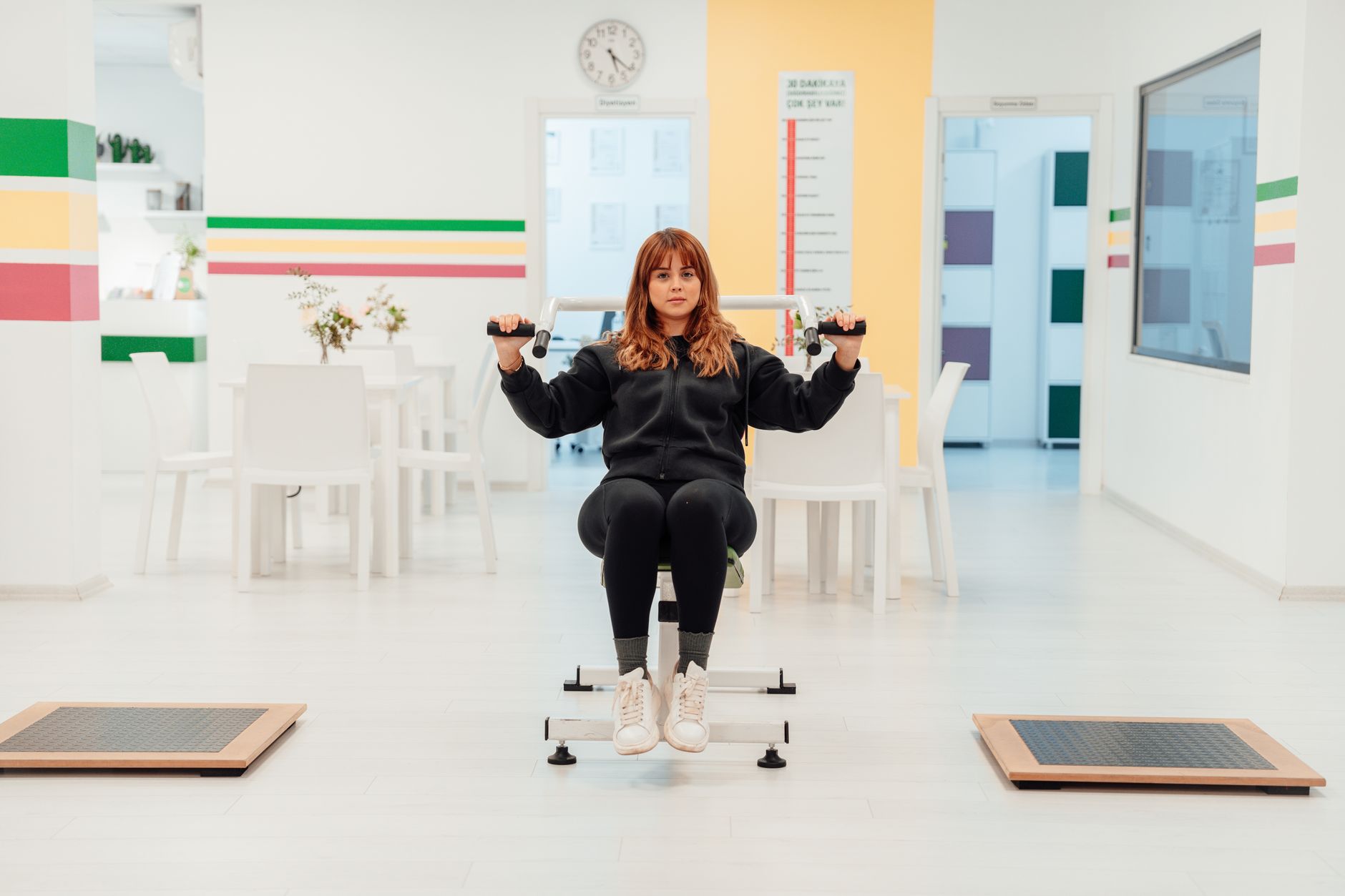 A person exercises in a Turkish clinic, using fitness equipment for rehabilitation.