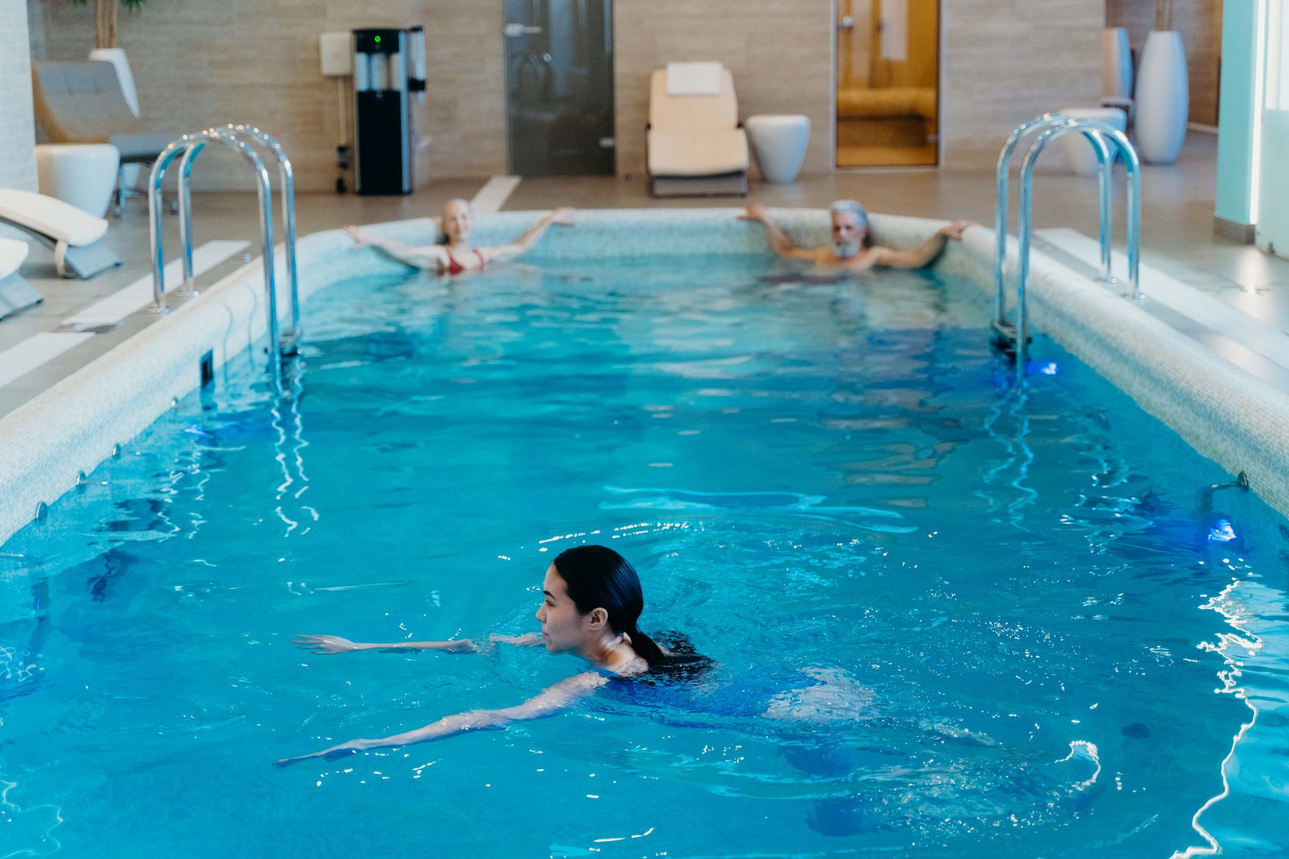 Patient practicing hydrotherapy in a modern pool at a Turkish rehab center.