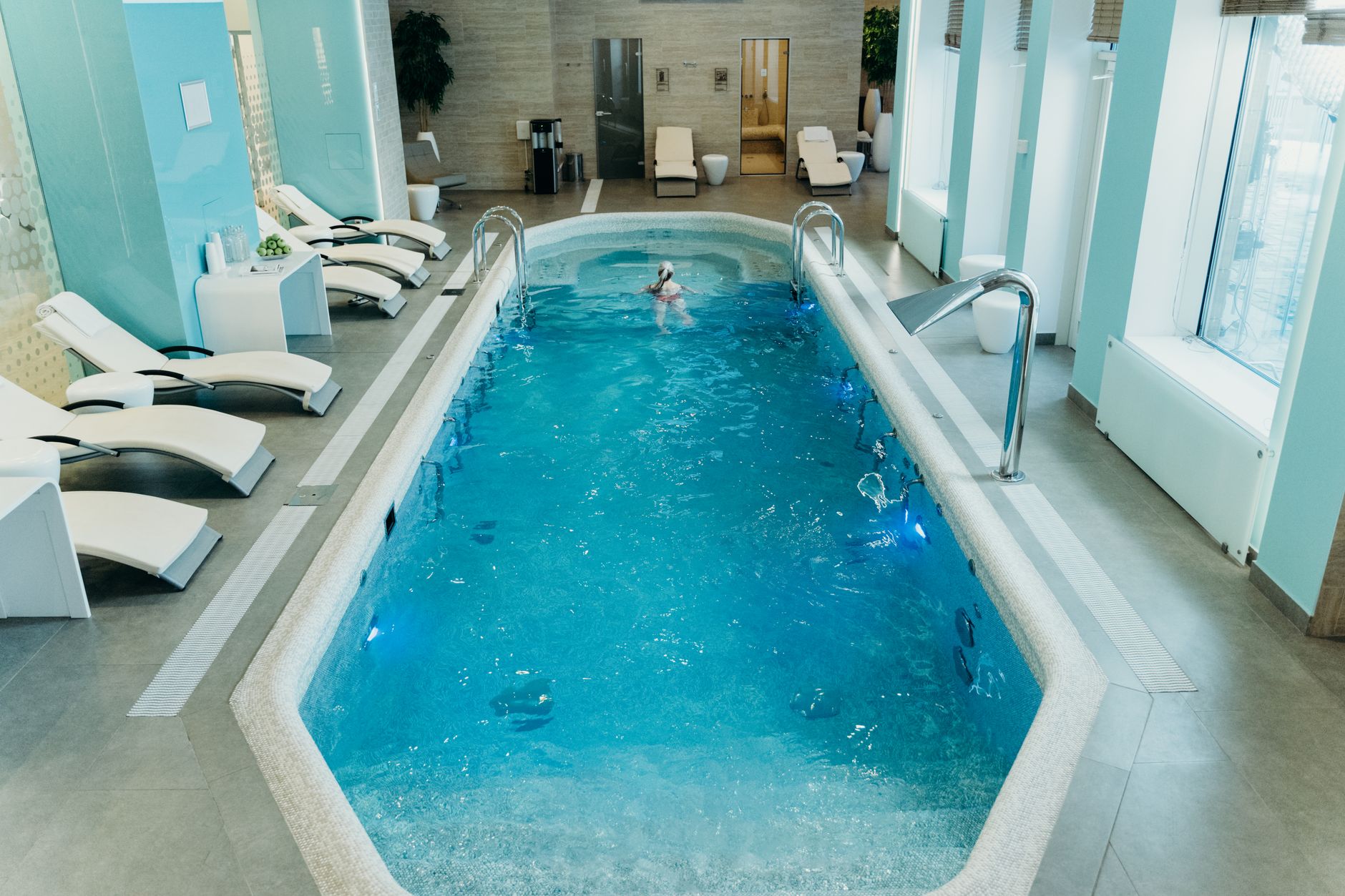 A tranquil spa area in a luxury hotel in Istanbul featuring a swimming pool and lounge chairs.