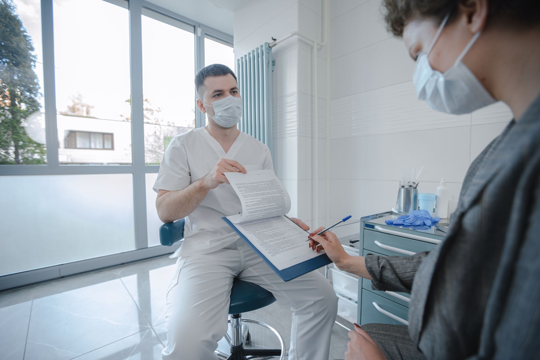 A male surgeon discusses a jawline contouring procedure with a patient.