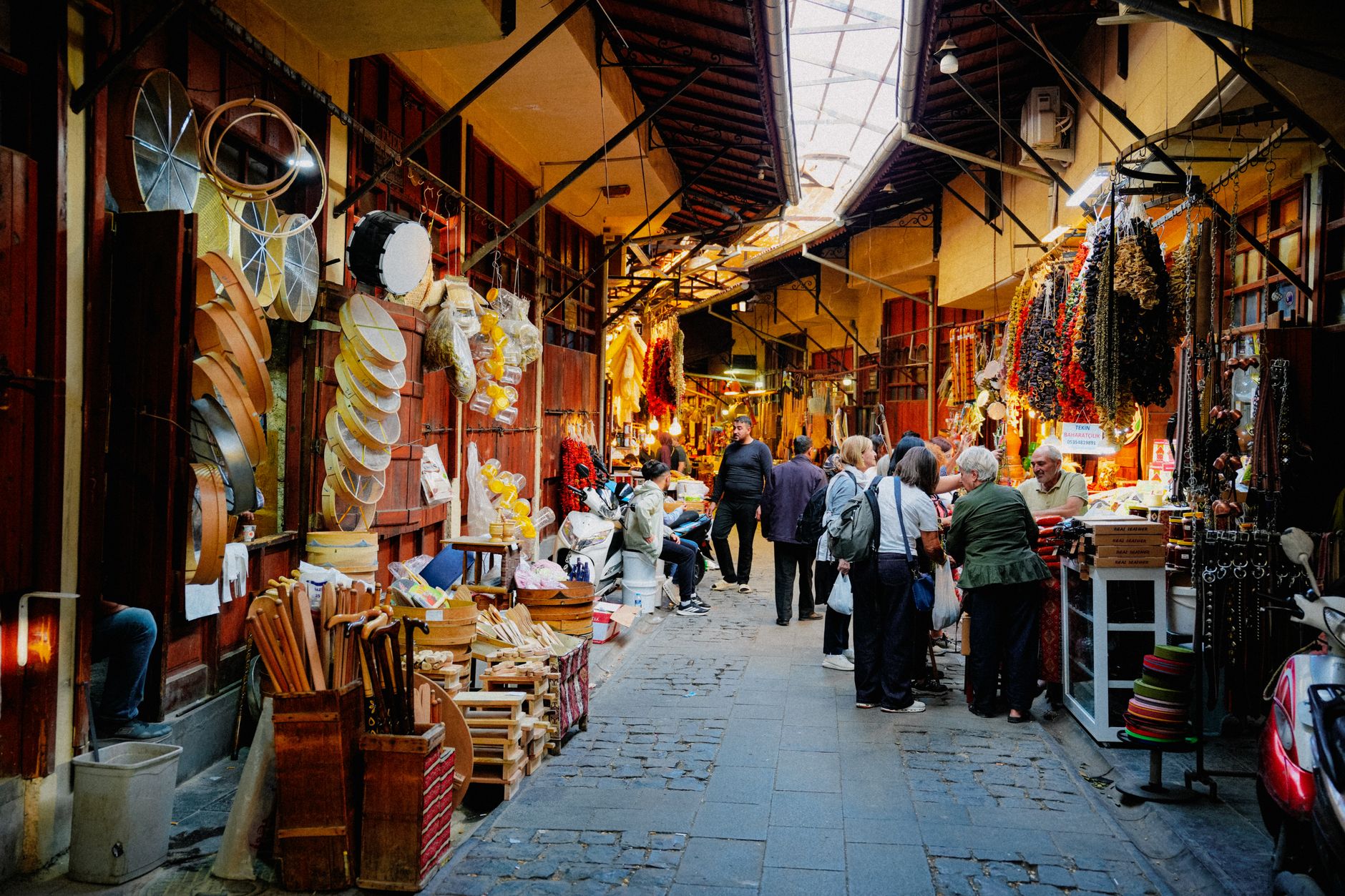 A bustling bazaar in Gaziantep filled with colorful ladles, molasses drums, and spice sacks.