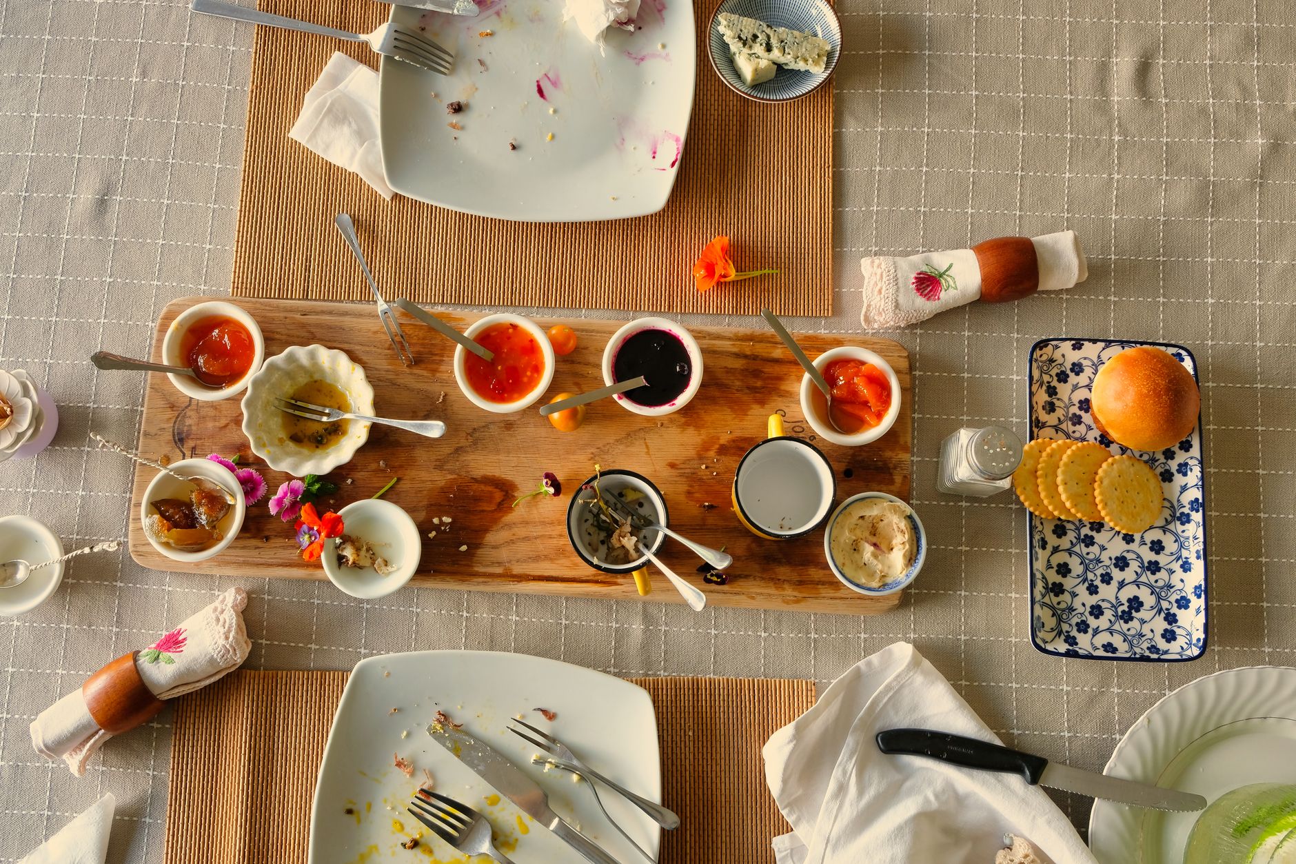 A beautifully arranged Turkish breakfast table with empty plates, fig preserves, and vibrant flowers.