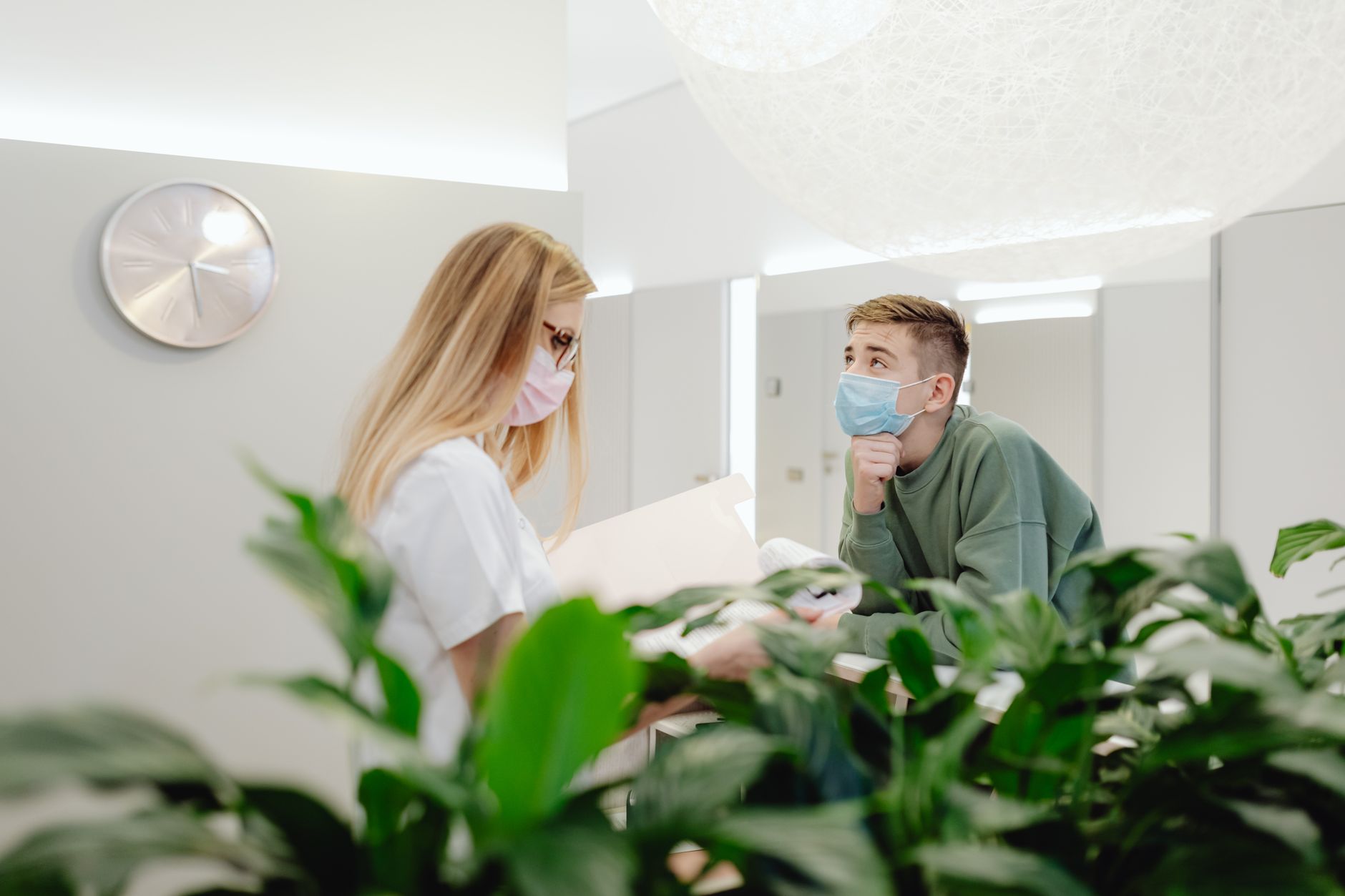A patient coordinator discusses updates with a family member in a modern clinic setting.