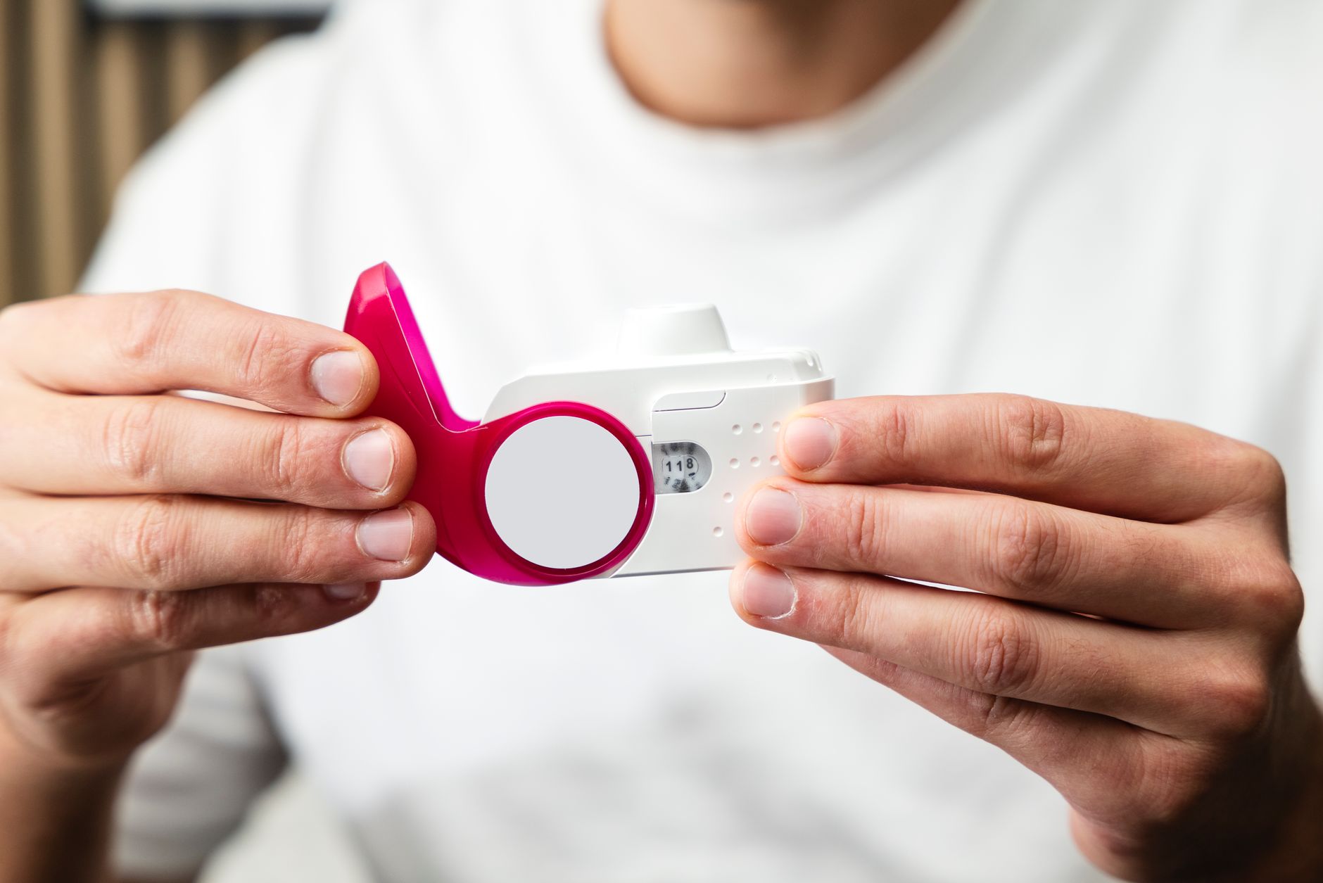 Close-up of a technician holding a pink spirometry testing device.