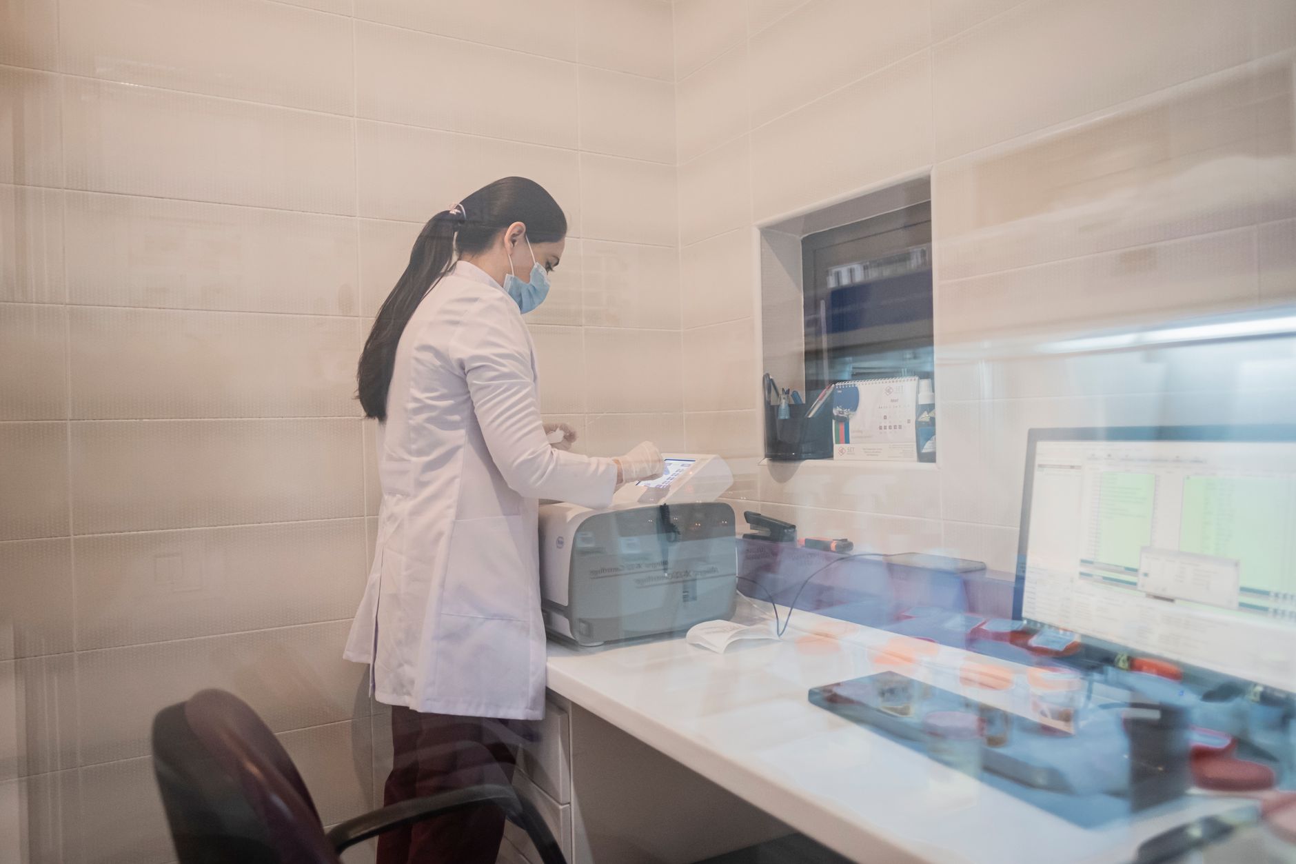 A technician in a lab coat conducting a pulmonary function test in a modern lab.