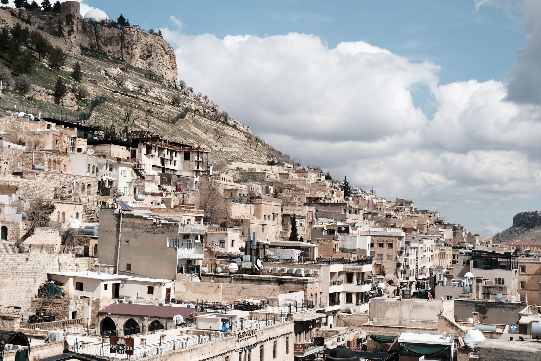 Panoramic view of Mardin's honey-stone terraces under soft golden light.