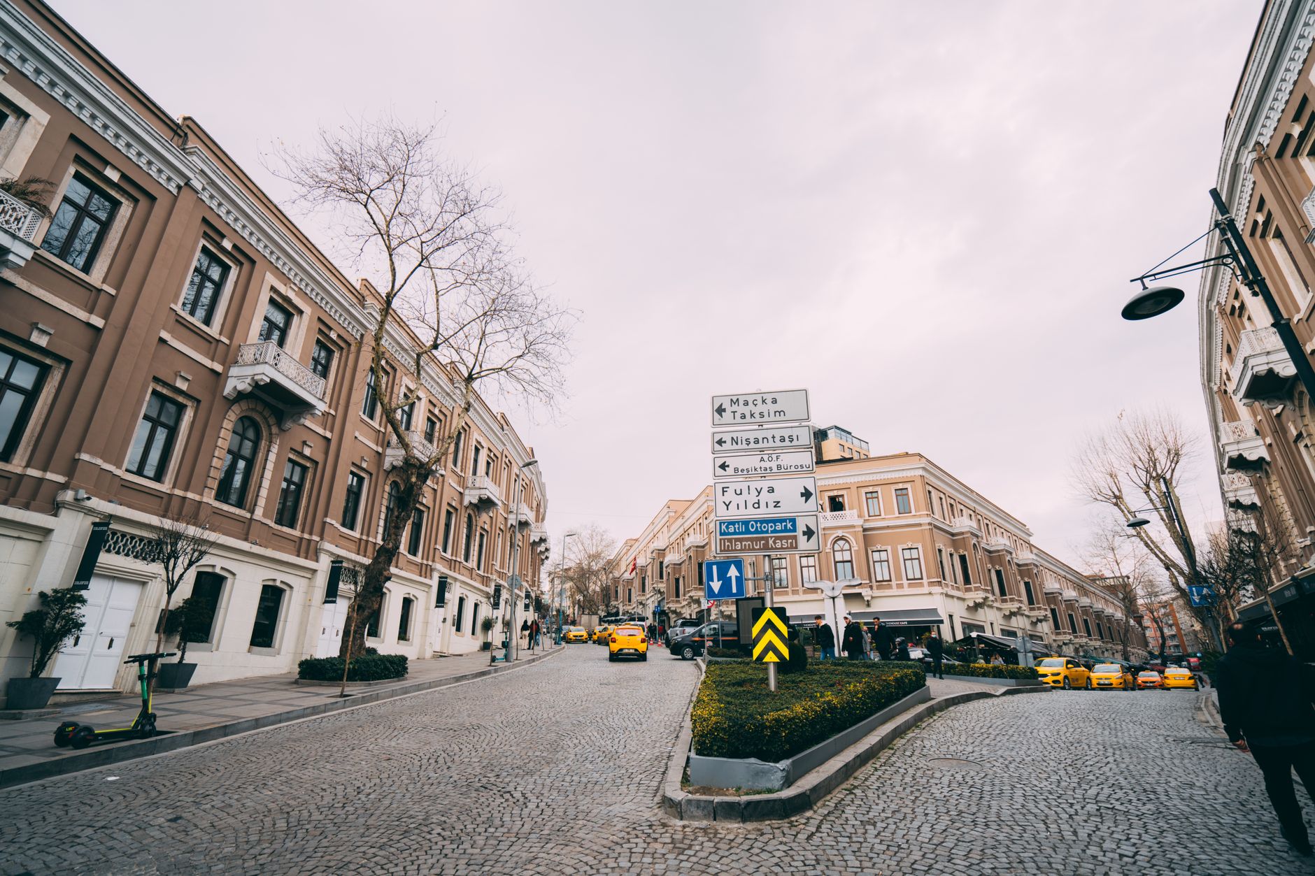 Scenic street in Nişantaşı, Istanbul, featuring vintage buildings and directional signs.