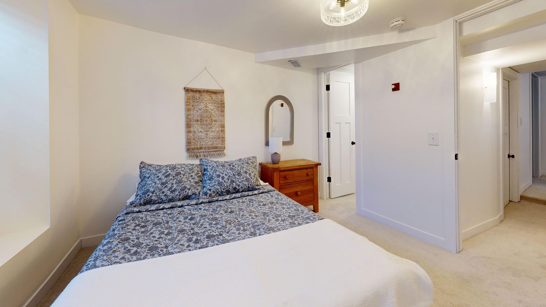 Comfortable sleep study room with a bed, light decor, and side table.