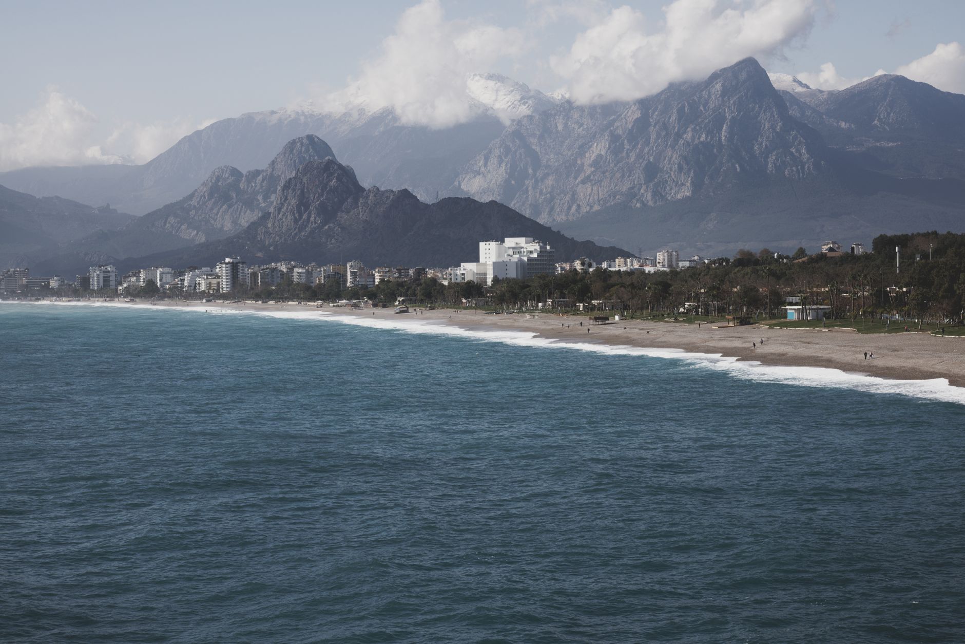 A serene view of a Turkish beach with mountains in the background, ideal for relaxation.