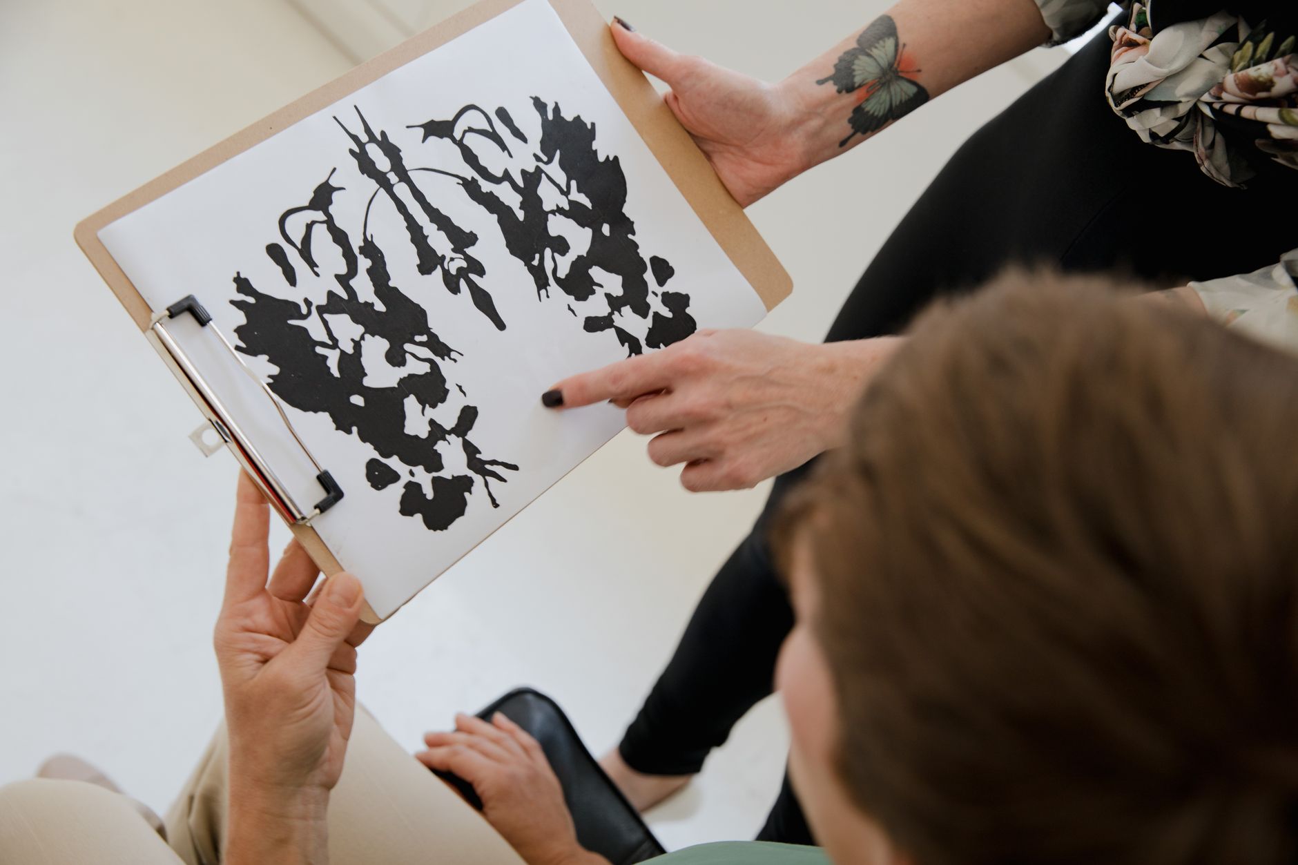Neuropsychologist showing Rorschach inkblot to a patient during assessment.